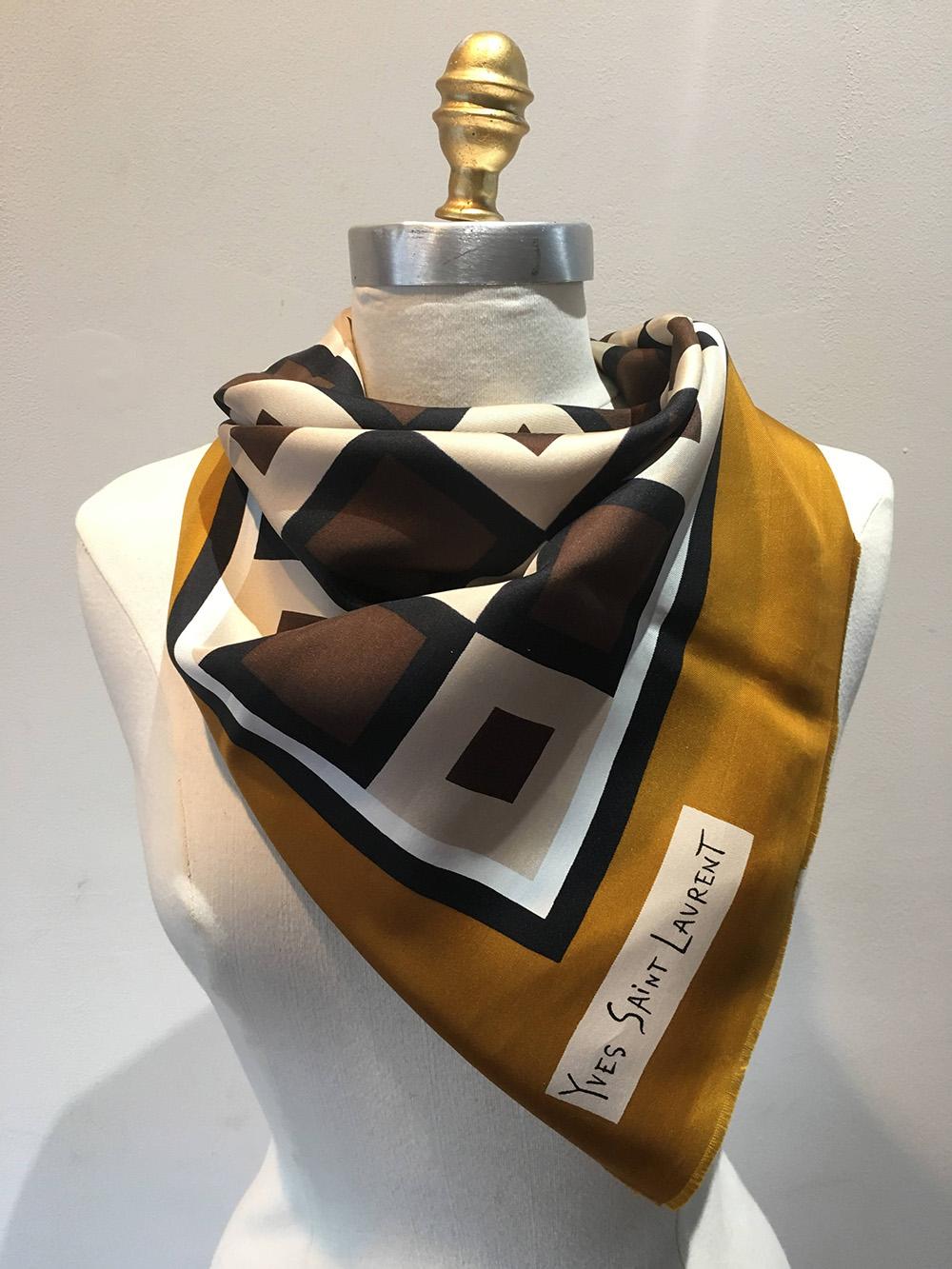 Vintage Yves Saint Laurent Golden Checkered Silk Scarf in very good condition. Woven silk twill with mid century modern retro print featuring dark golden border surrounding a centered brown, black and cream square checkered print. 100% silk. made in