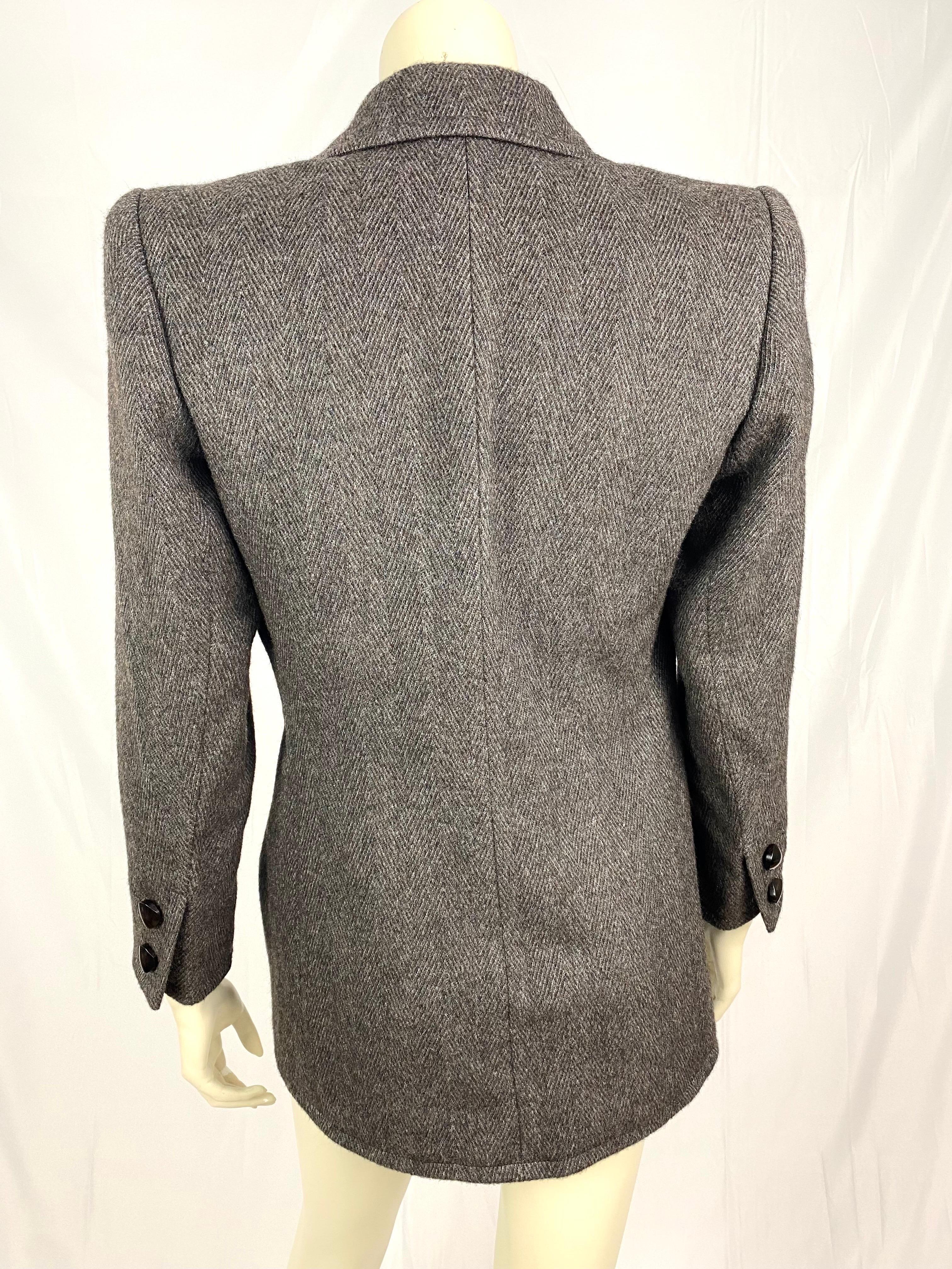 Stunning vintage Yves Saint Laurent Haute Couture numbered blazer.
Structured and very elegant with its slightly pagoda shoulders.
Nicely fitted with an imposing and unique wooden button to close the blazer.
Herringbone in brown/taupe and grey.
The