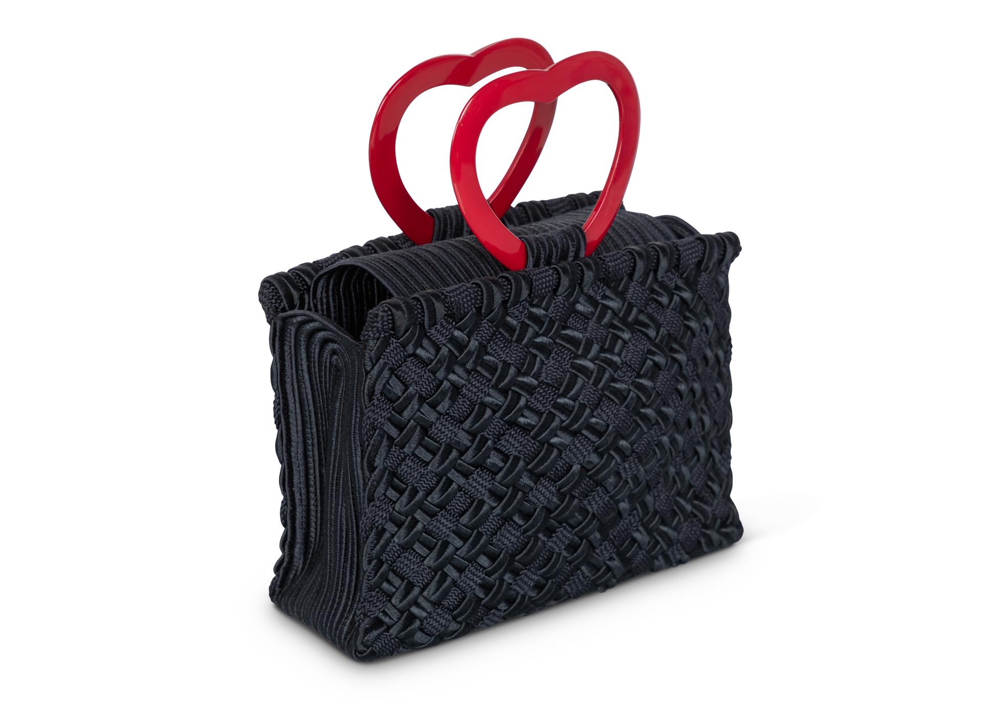 Sac Vintage Yves Saint Laurent Passementerie à poignée en Lucite. Les poignées du cœur sont en lucite rouge brillant, et le corps du sac est noir et magnifiquement tissé de trois textures différentes.
En parfait état. Les pièces vintage de haute