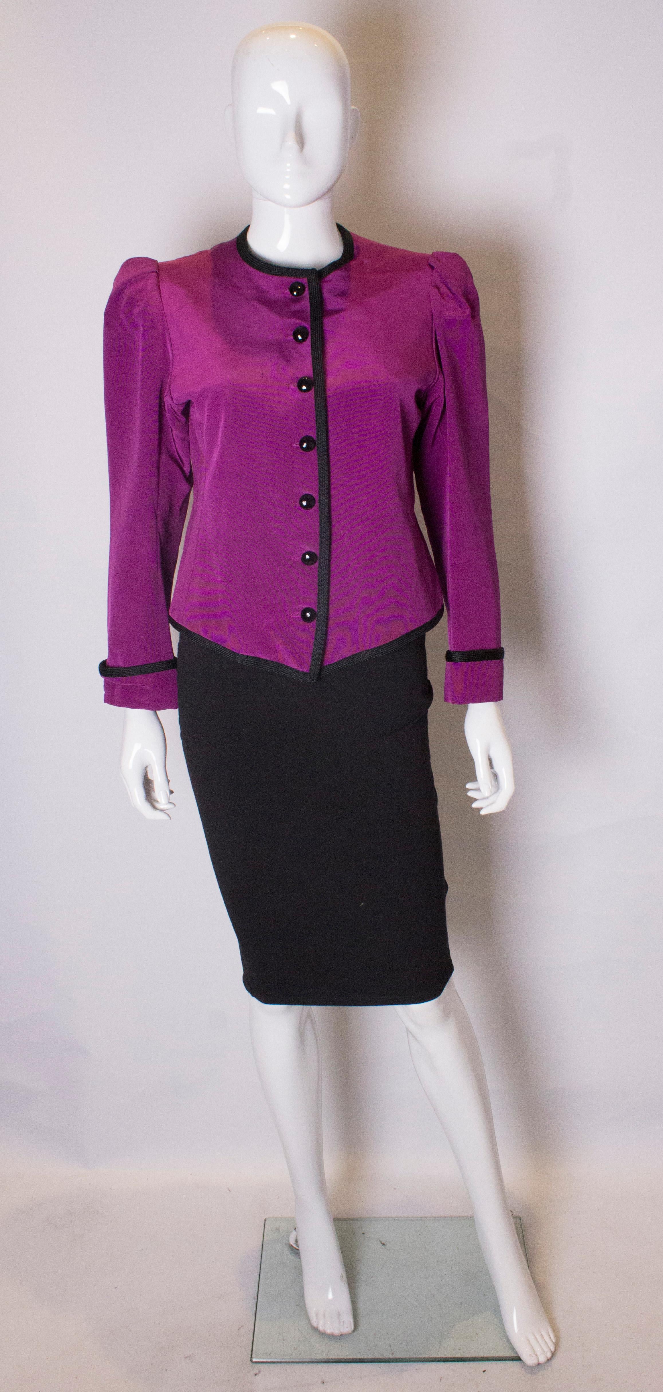 A great jacket for fall /winter by Yves saint Laurent, Rive Gauche line.
In a stunning purple colour, the jacket has gathered shoulders, with black trim along the hem,neckline , front and cuffs. It has a seven button opening at the front.