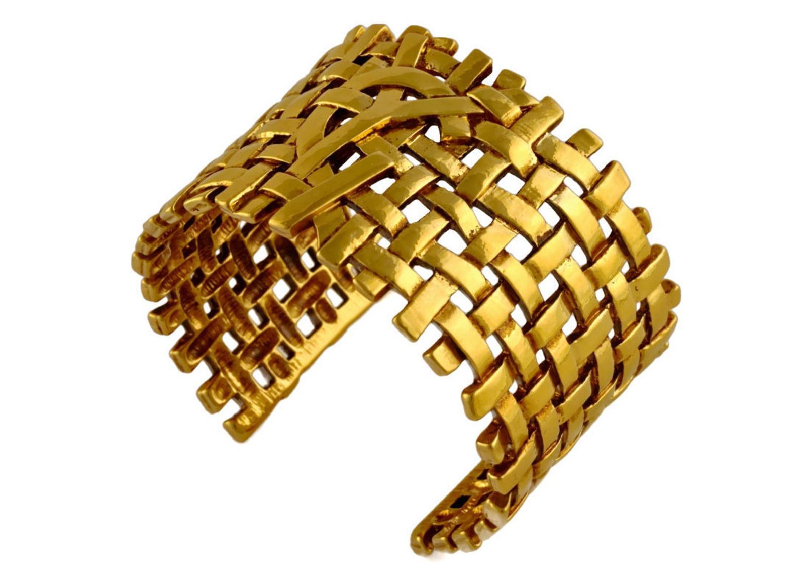 Vintage YVES SAINT LAURENT Logo Woven Cuff Bracelet

Measurements:
Height: 1 5/8 inches
Inside Diameter: 2 2/8 inches (across)
Opening: 1 2/8 inches

Features:
- 100% Authentic YVES SAINT LAURENT.
- Woven metal bracelet cuff.
- Raised YSL logo at