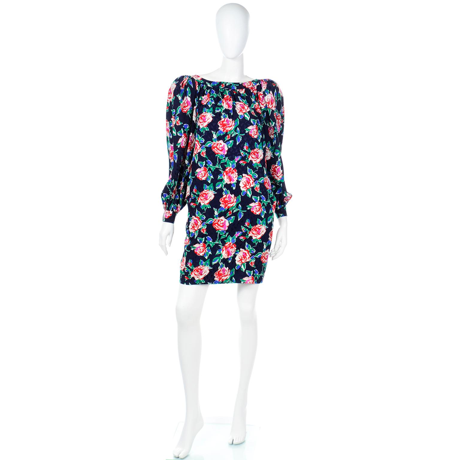 This wonderful vintage Yves Saint Laurent 1980's silk dress is in a navy blue, green, red, pink and white floral print.This dress has a slight off-the-shoulder style with a thick band around the neckline that creates a pleated and gathered effect,