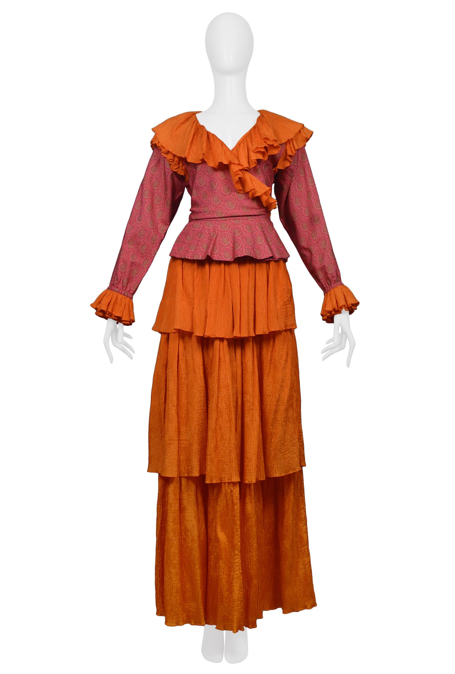 Vintage Yves Saint Laurent bright orange and fuchsia pink silk two piece set. Wrap blouse features a paisley-esque print and is decorated with classic YSL orange pleated ruffles. The orange maxi skirt features three tiers of pleated ruffles. Circa