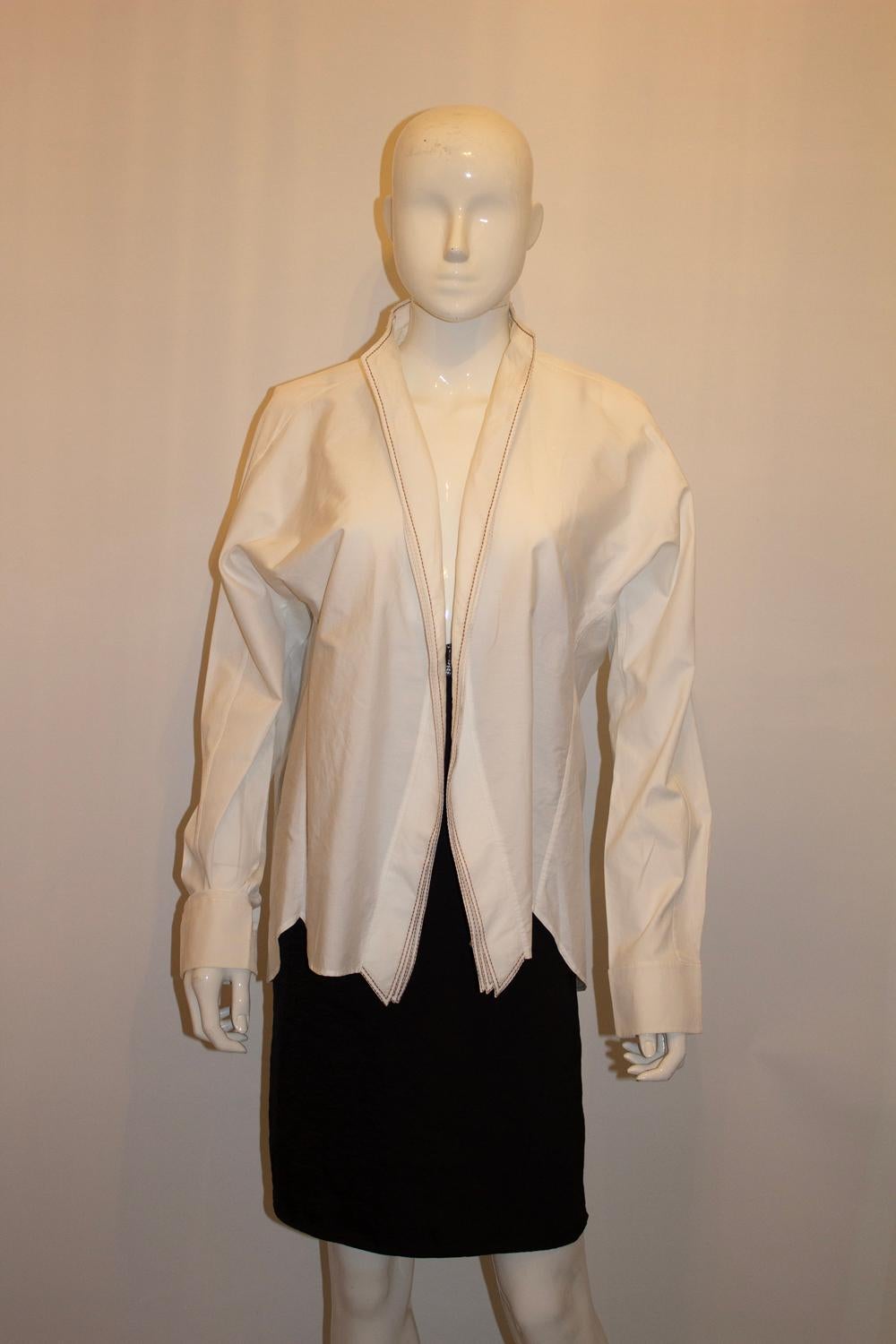Forse una delle prime camicie/giacca vintage in cotone di Yves Saint Laurent. 
In un meraviglioso cotone bianco con dettagli di cuciture marroni e polsini con bottoni, la camicia è un'ottima aggiunta a qualsiasi guardaroba.
Taglia EU 46, made in