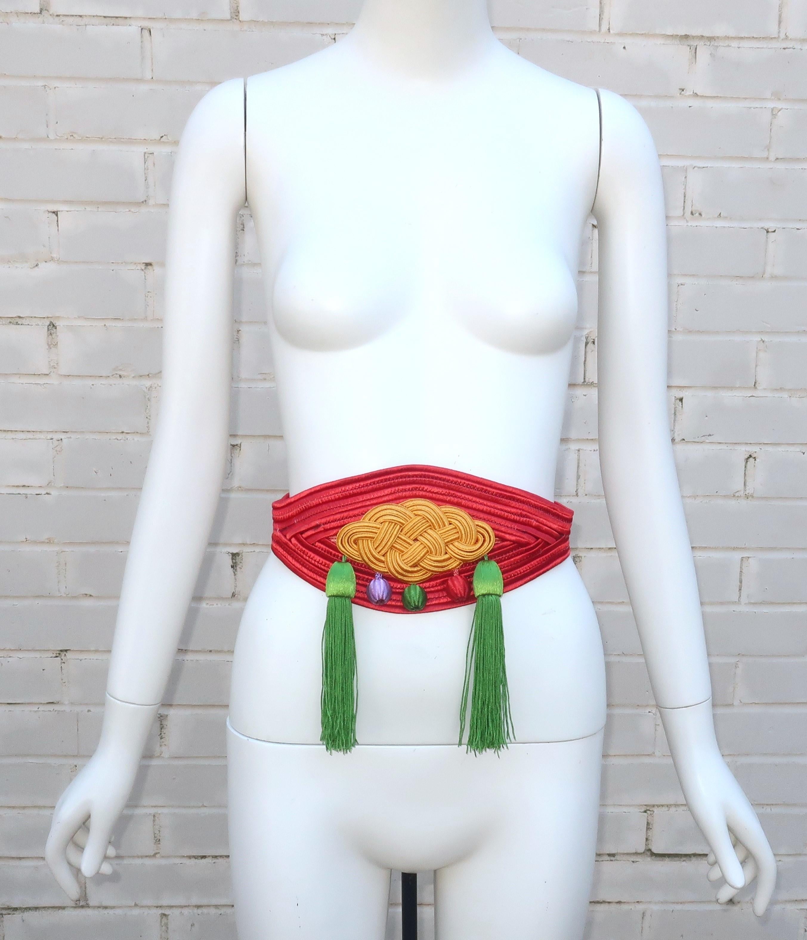 Vintage Yves Saint Laurent cummerbund style belt designed in silk passementerie with tassels. The opulent look is pure YSL with an eye catching combination of colors including red, yellow, green and lilac.  The belt hooks and snaps at the back with