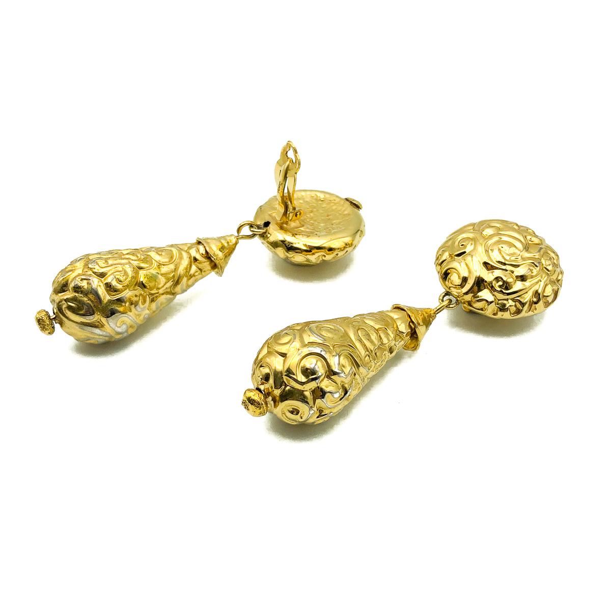 A magnificent pair of Vintage YSL Bomb Earrings. Crafted in gold plated metal. A large bomb style drop hangs from a button style clip on top. In very good vintage condition, signed, a very long approx. 9cm drop. An incredible pair of timeless
