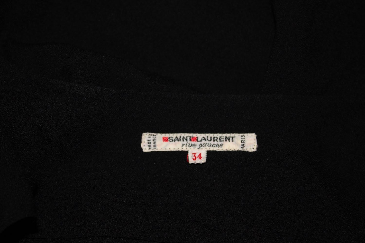 Un grand  Veste noire vintage facile à porter, Yves Saint Laurent Rive Gauche. La veste est en crêpe noir, avec des poignets boutonnés et des plis sur l'épaule. La tenue n'est pas serrée. Taille 34.
Mesures Buste 35'' longueur 25''