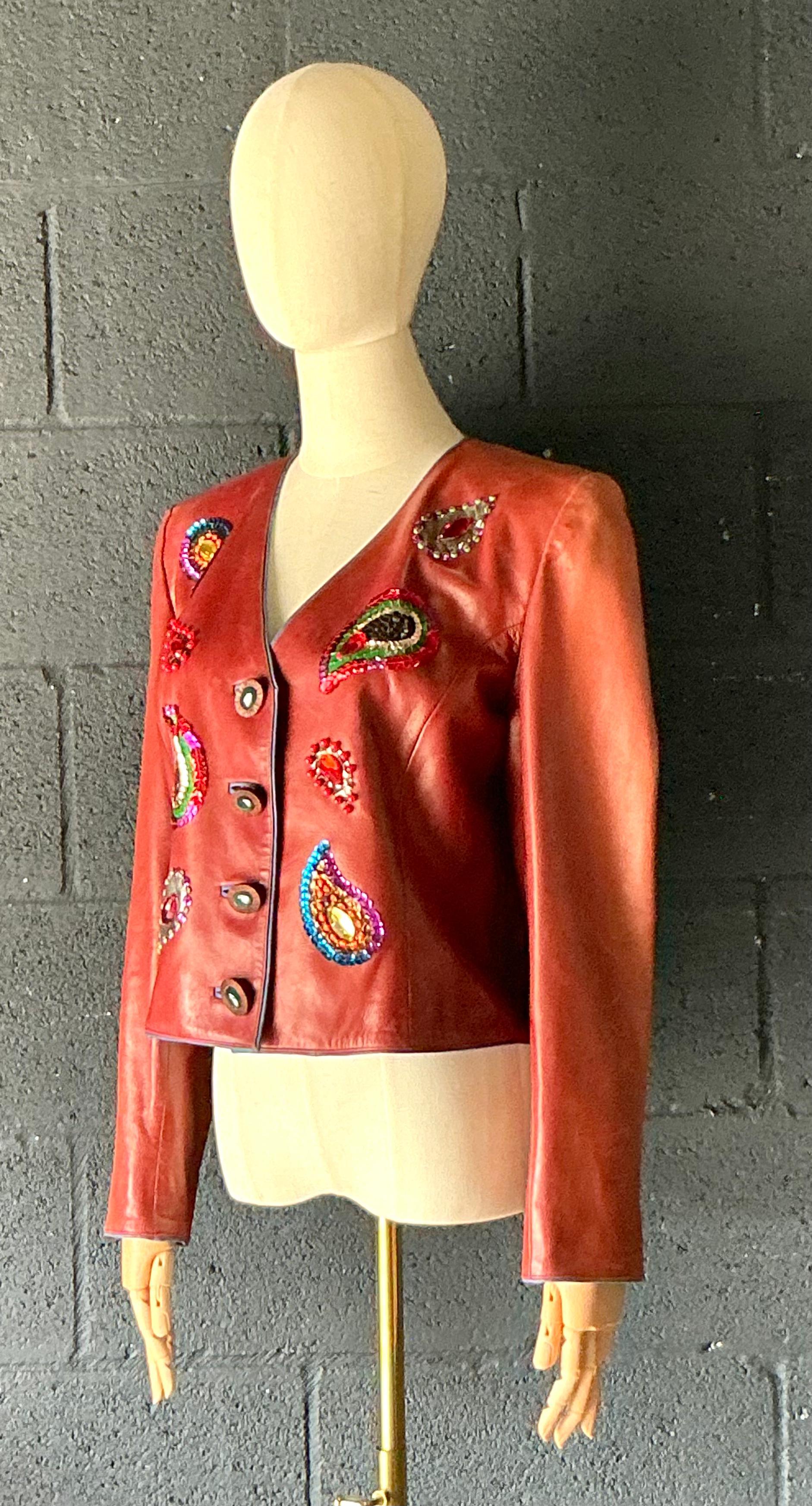 Diese Vintage-Lederjacke von Yves Saint Laurent mit Rive Gauche-Verzierungen ist ein seltenes und auffälliges Stück, das den kühnen, avantgardistischen Geist des Hauses unterstreicht. Die aus hochwertigem Leder gefertigte Jacke ist mit aufwendigen