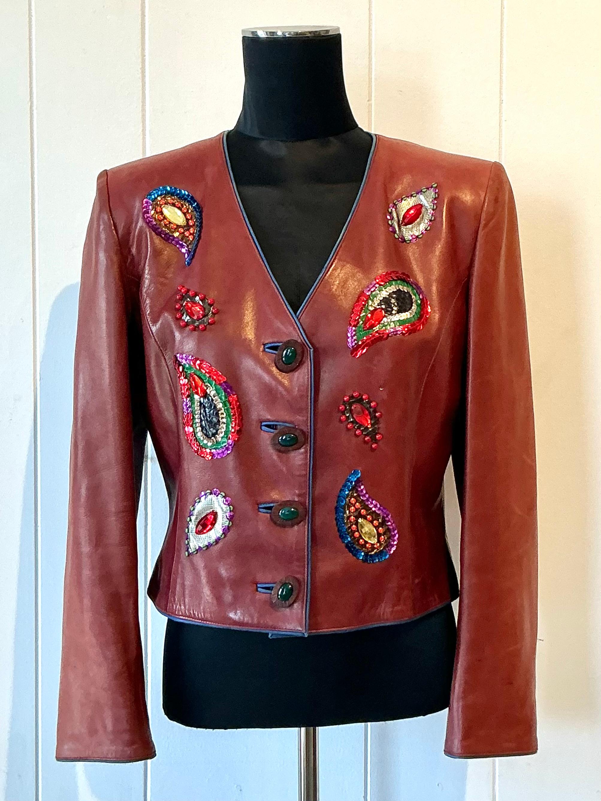This vintage Yves Saint Laurent Rive Gauche embellished leather jacket is a rare and striking statement piece that showcases the house’s bold, avant-garde spirit. Crafted from high-quality leather, the jacket features intricate embellishments —