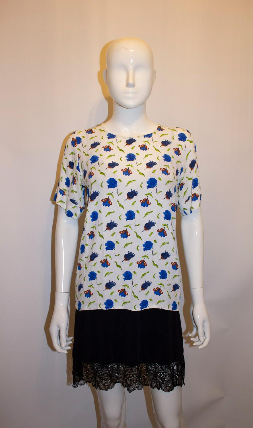 A pretty and easy to wear vintage top by Yves Saint Laurent , Rive Gauche . The top has a white background with a blue, grey and brown floral print. Size 36 Measurements: Bust up to 37'', length 25''