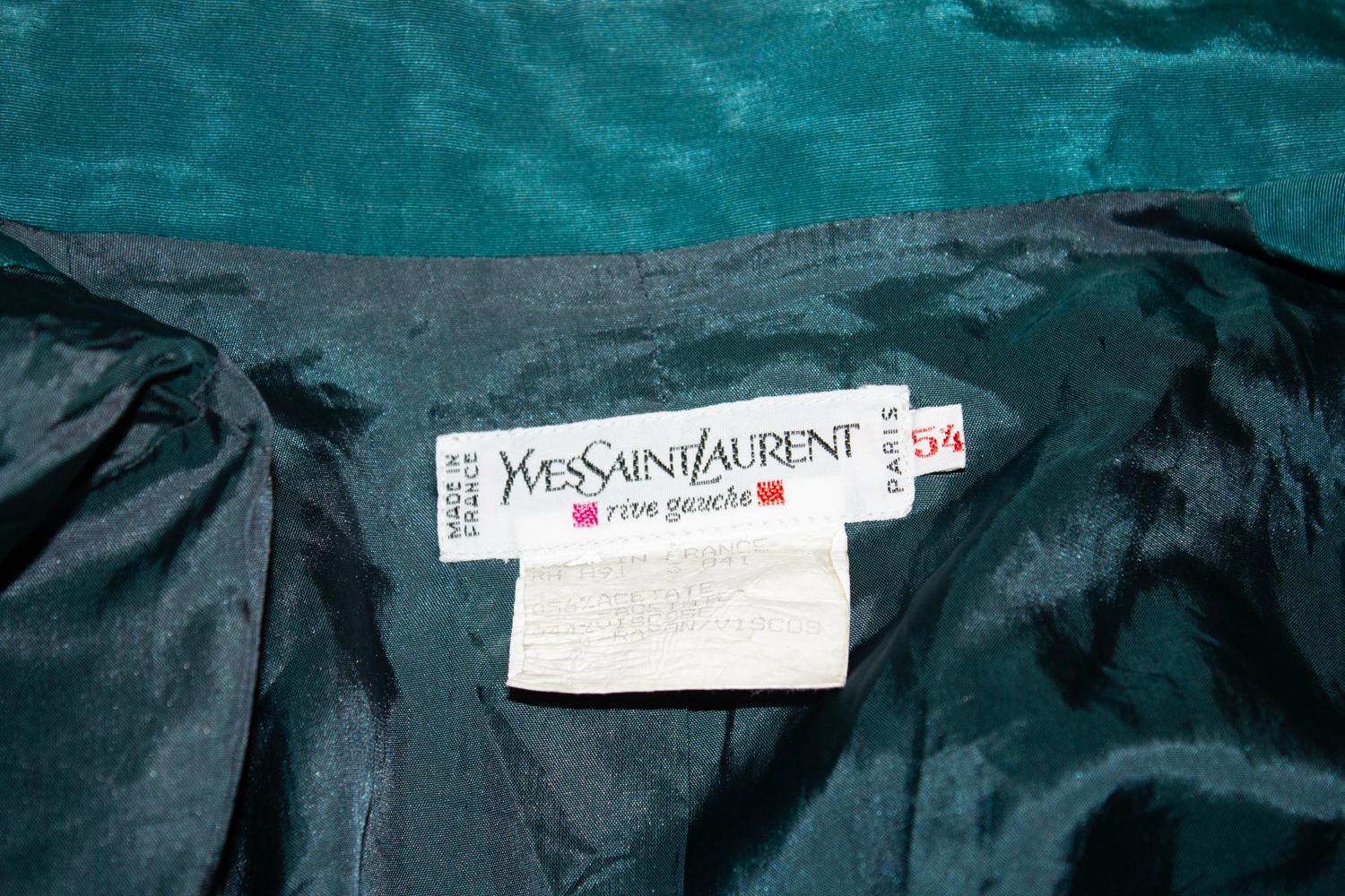 Una meravigliosa giacca vintage di Yves Saint Laurent Rive Gauche. Risale al 1991, taglia 54, in un tessuto moresco simile alla seta di un attraente colore verde mare. La giacca è dotata di due tasche basse e di un taschino sul petto con un bottone