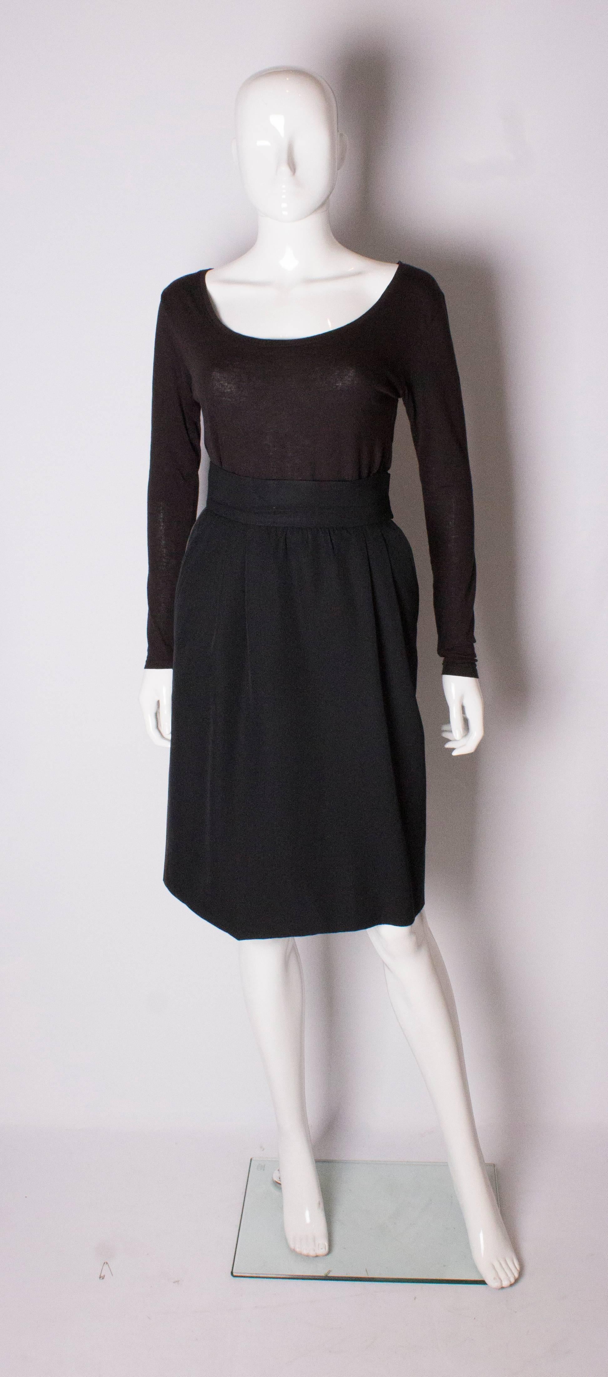 A chic vintage skirt 'Le Smoking' tuxedo  by Yves Saint Laurent Rive Gauche. The skirt is wool and fully lined, with sloping pockets and a zip on the left hand side. It has gathering on the front and ribbon detail on the left hand side.
