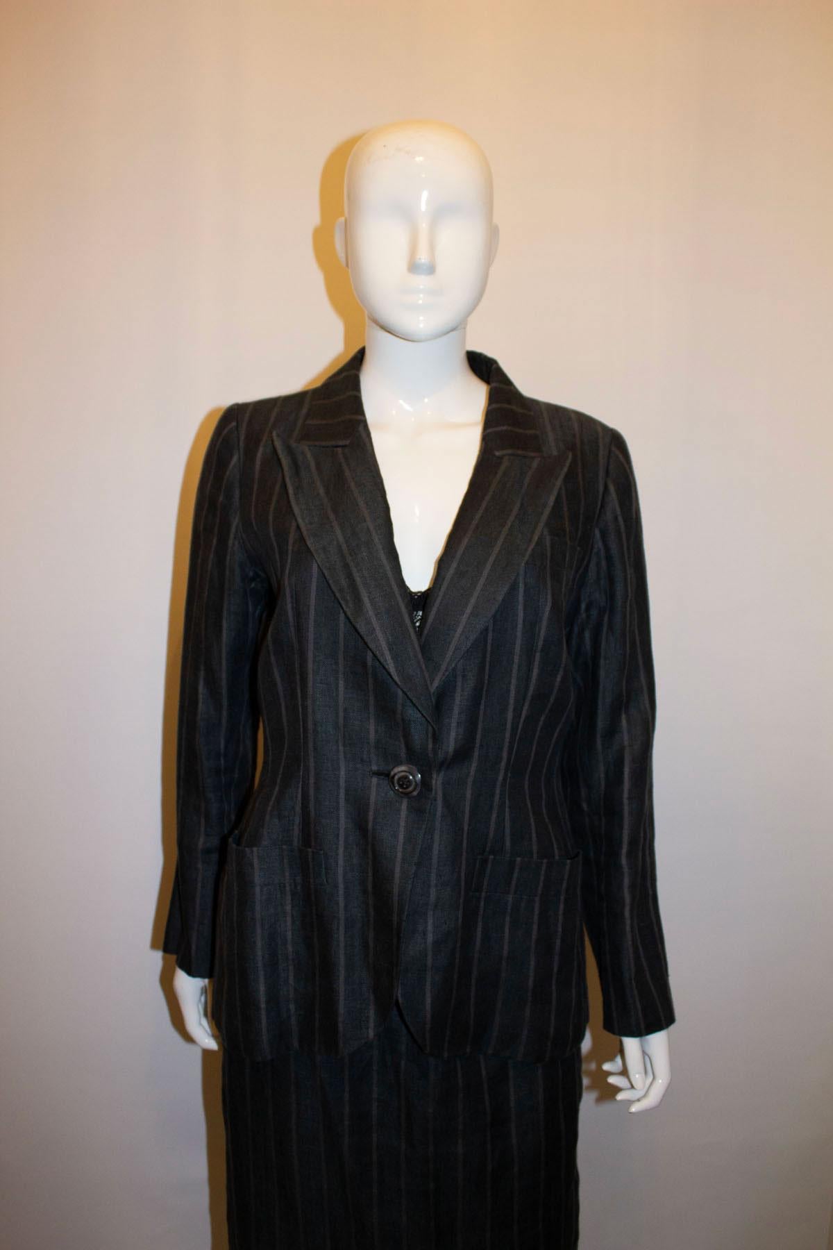 Un superbe tailleur jupe pour le printemps/été, par Yves Saint Laurent Rive Gauche datant des années 1980. 
Le costume est en lin, avec une bande de craie et une armure à chevrons. La veste est munie d'un bouton unique, de deux  sur le devant et une