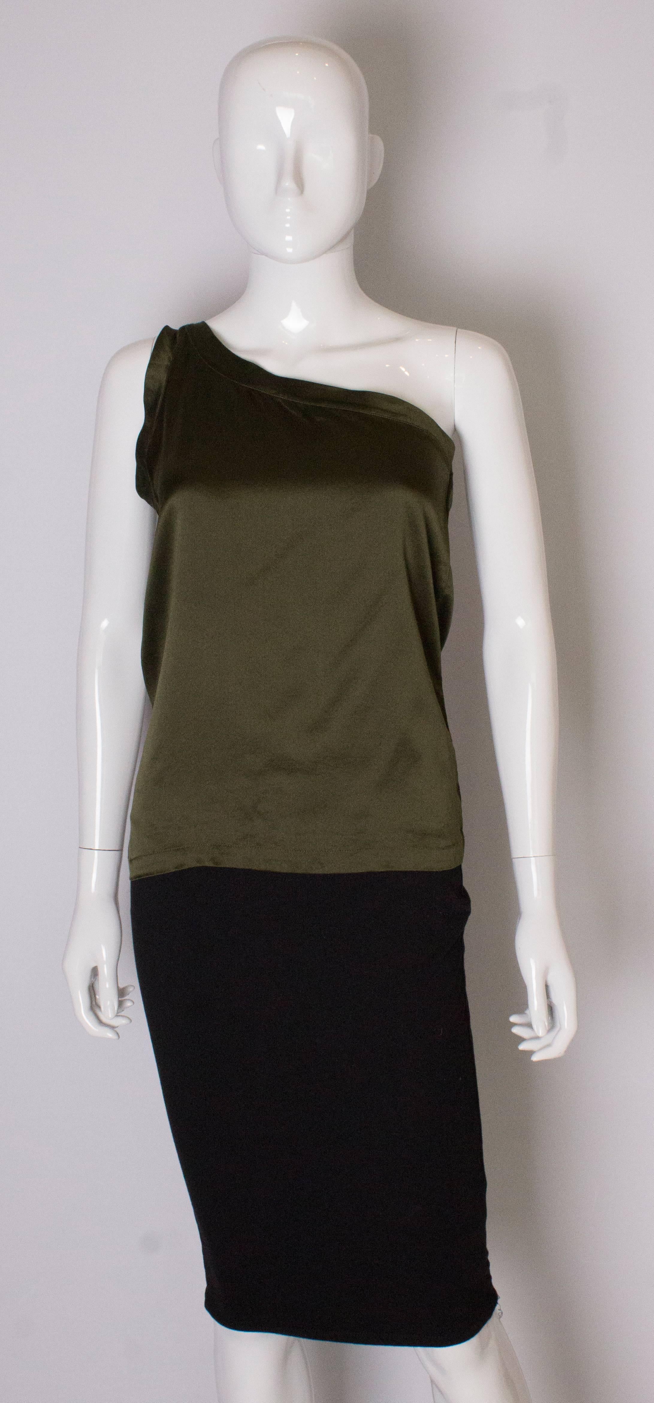 A chic, silk top by Yves Saint Laurent , Rive Gauche. The top is in an olive green colour, with one shoulder.