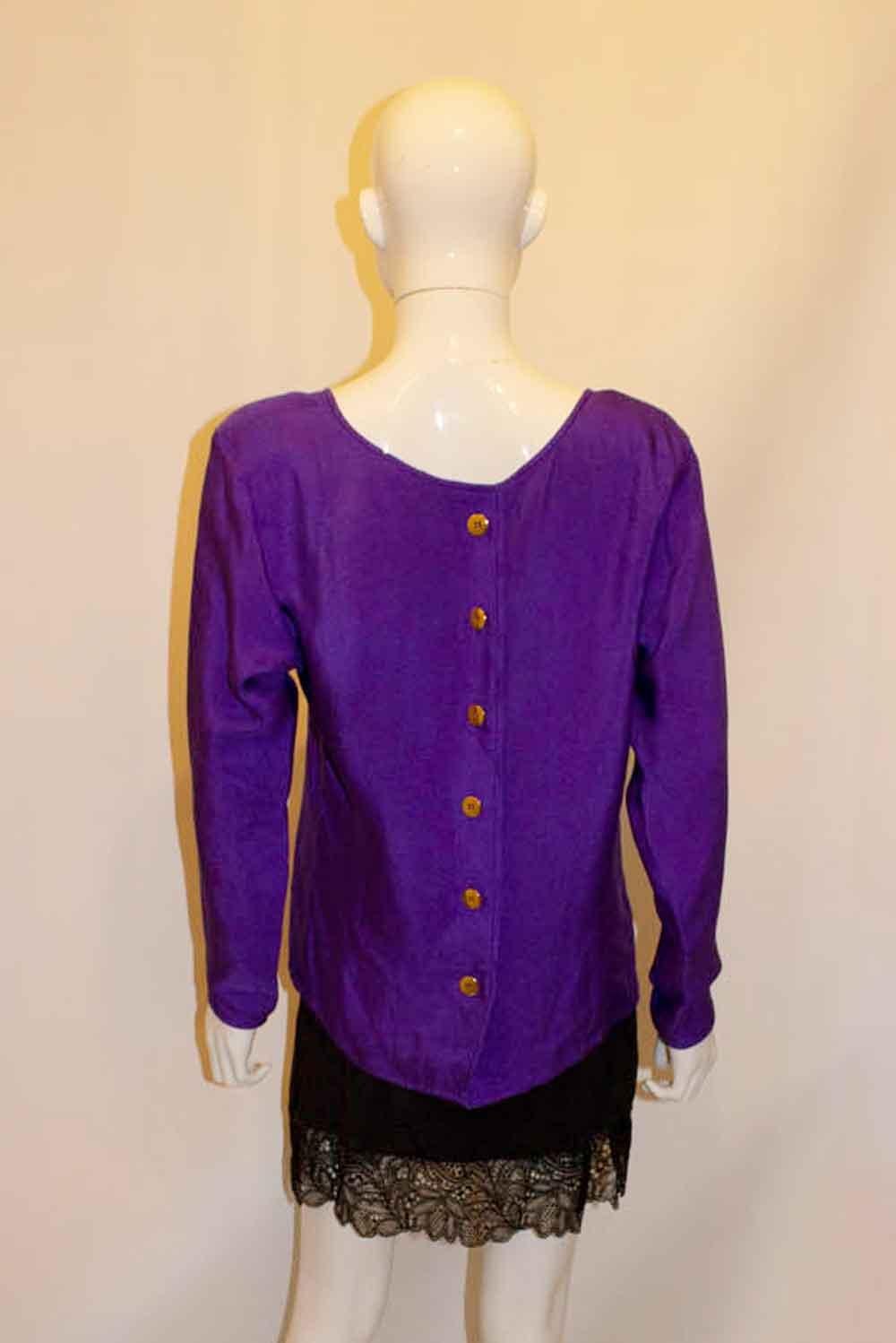 A stylish vintage silk top by Yves saint Laurent Rive Gauche. In a purple textured silk, the top has a round neckline and six button fastening at the back. Measurements: bust up to 39'',length 26'''
