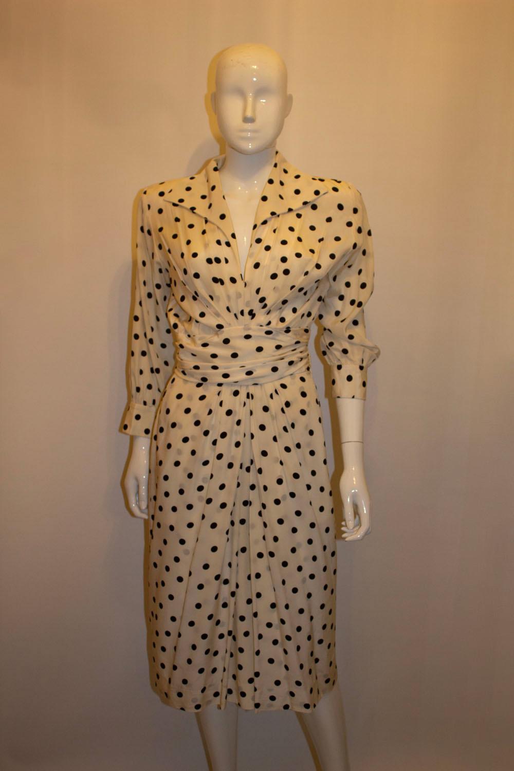 A super vintage silk dress b Yves Saint Laurent Rive Gauche. The dress is in white sil with black spot print. It has a v neckline, the original shoulder pads ( could be removed), and a pocket on either side .
Made in France , Size 40 
Measurements: