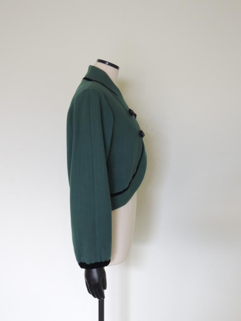 Se trata de una chaqueta vintage YSL Rive Gauche de lana verde. Dos cierres delanteros de lazo/botón, ribete de terciopelo. La lana tiene un aspecto texturizado, casi acanalado. En la etiqueta pone H94, ¿quizás invierno de 1994? No lo sé con
