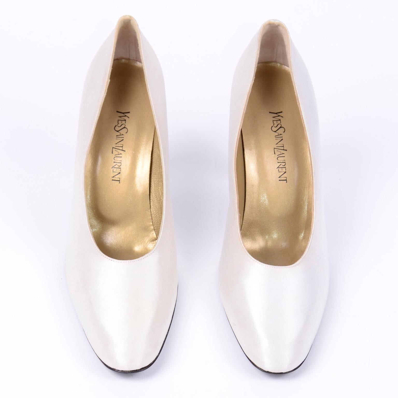 These classic Yves Saint Laurent vintage white pumps would be perfect to wear to that Summer special event or as bridal wedding shoes. These vintage YSL white satin shoes have black leather soles and were never worn. There are a few smudges on satin