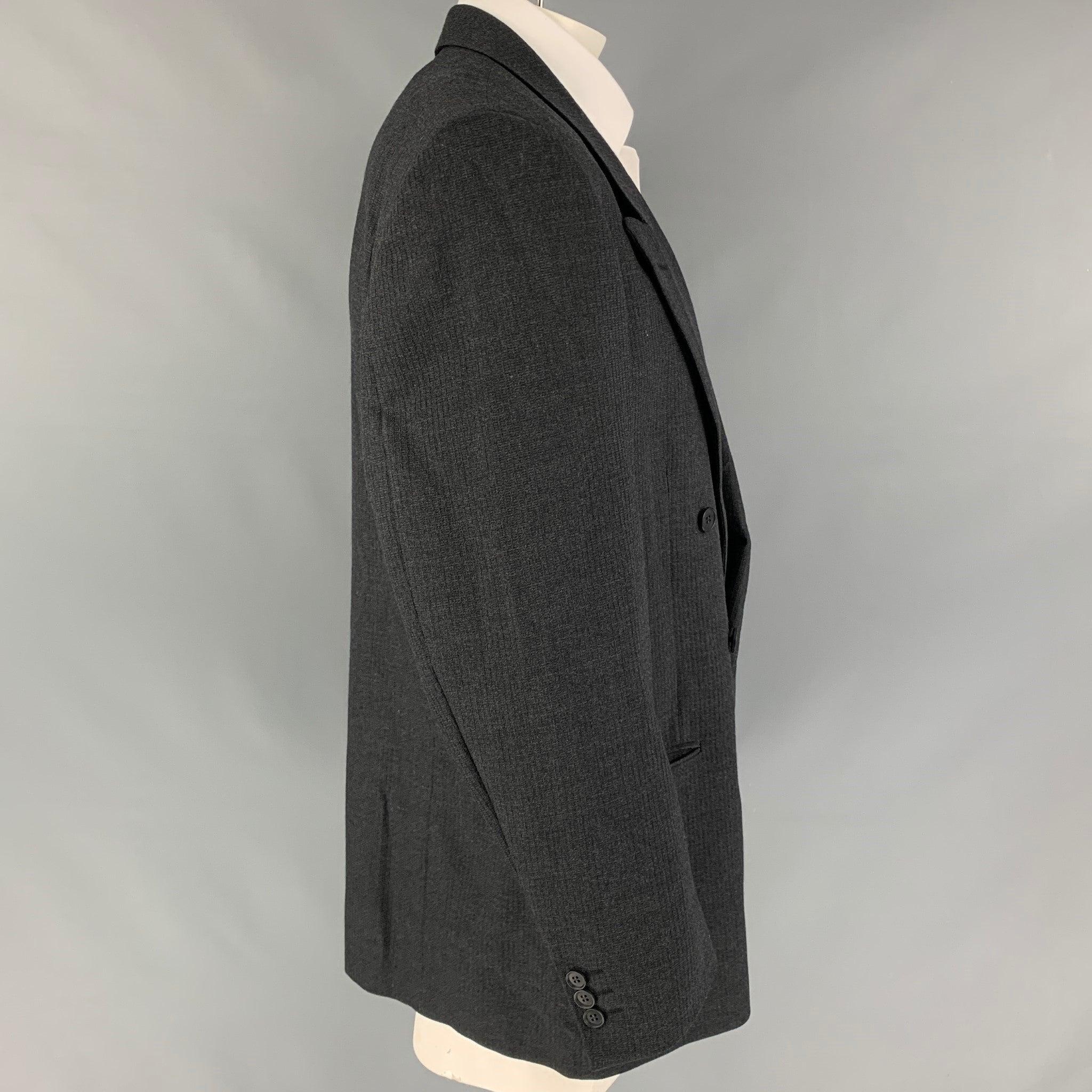 Vintage YVES SAINT LAURENT sport coat comes in a dark gray textured wool with a full monogram liner featuring a peak lapel, slit pockets, and a double breasted closure. Made in Canada.
Very Good
Pre-Owned Condition. 

Marked:   Fabric tag removed 