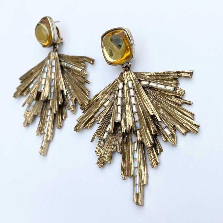 Collector! Sublime Yves Saint Laurent stud earrings in aged gold metal paved in places with rectangular rhinestones. 
At the level of the attachment, a rounded dome in light yellow resin is the start of these ridged golden metal rods. 
Dimensions :