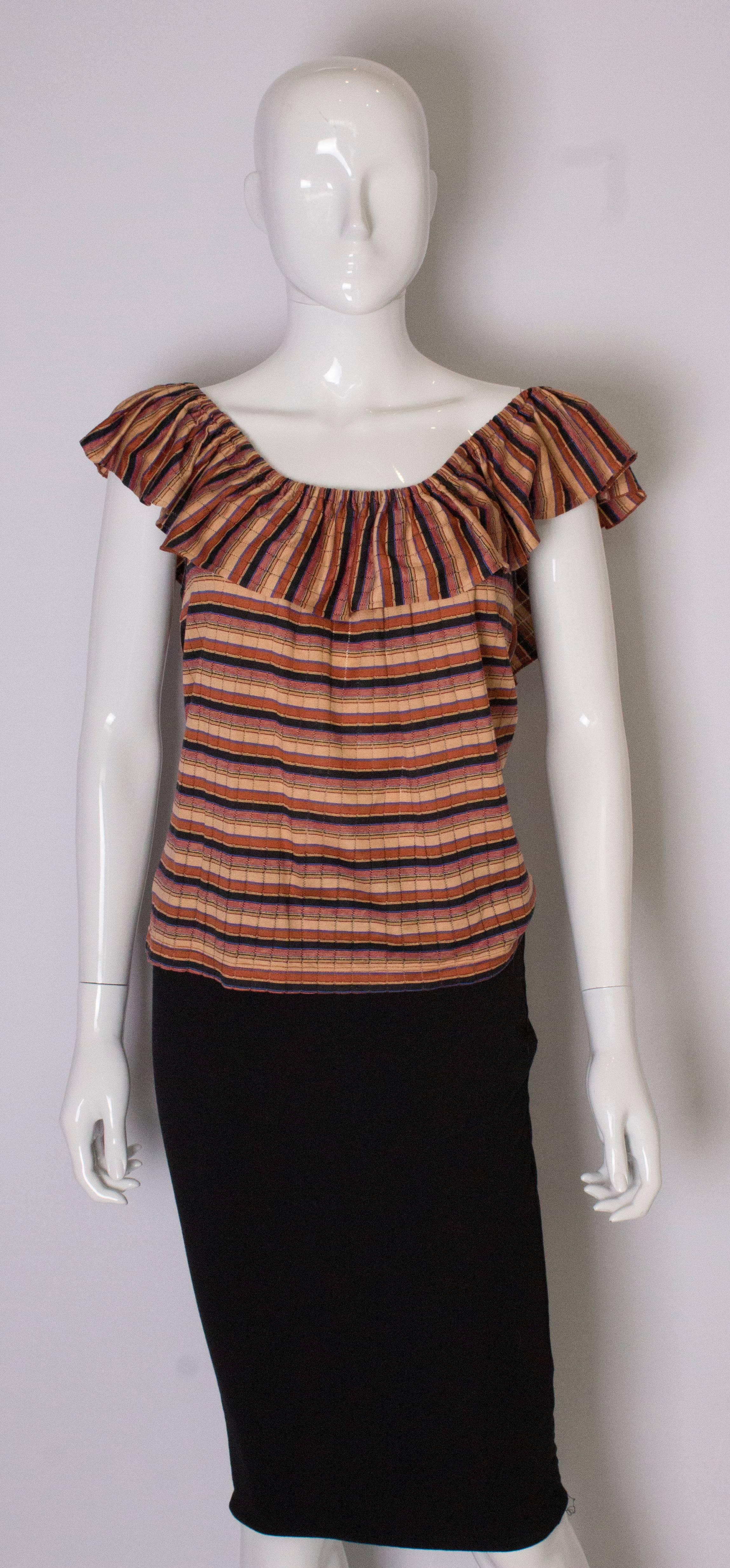 A chic vintage top for Summer , by Yves Saint Laurent , Tricot line. The top has horizontal stripes in rust, apricot, blue and black  on the body and vertical stripes in the same colour on the frill. The fabric is 90 % cotton and 10% lurex. 