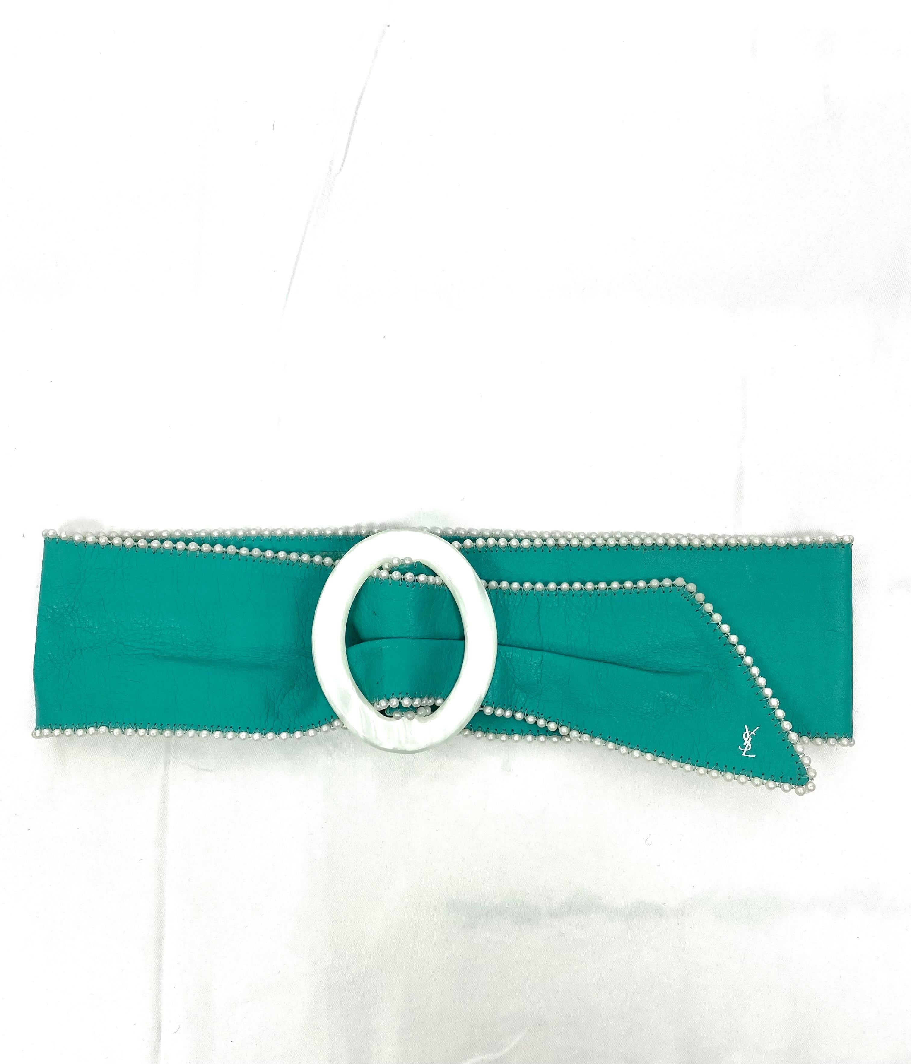 Vintage Yves Saint Laurent belt in turquoise leather, adorned with small white pearls, pretty and imposing pearly buckle (9cm x 7.5cm)
Small YSL logo at the end of the belt.
Size 70/28 adaptable
Total length 85cm
Width 8.5cm

some slight traces of