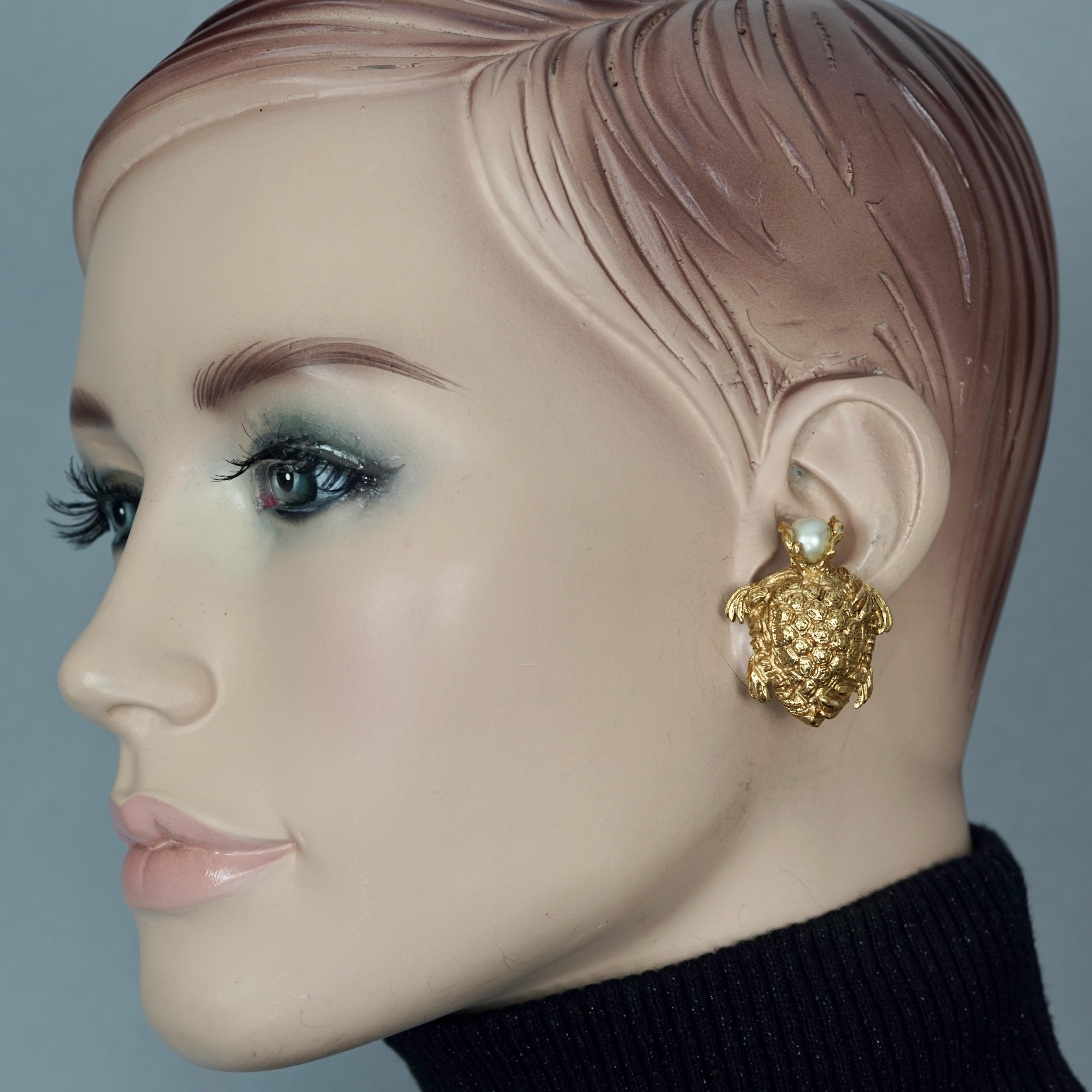 Vintage YVES SAINT LAURENT Turtle Pearl Earrings

Measurements:
Height: 1 3/8 inches
Width: 1 1/8 inches

Features:
- 100% Authentic YVES SAINT LAURENT .
- Chunky detailed turtle earrings with pearl head.
- Gold tone.
- Clip back earrings.
- Signed