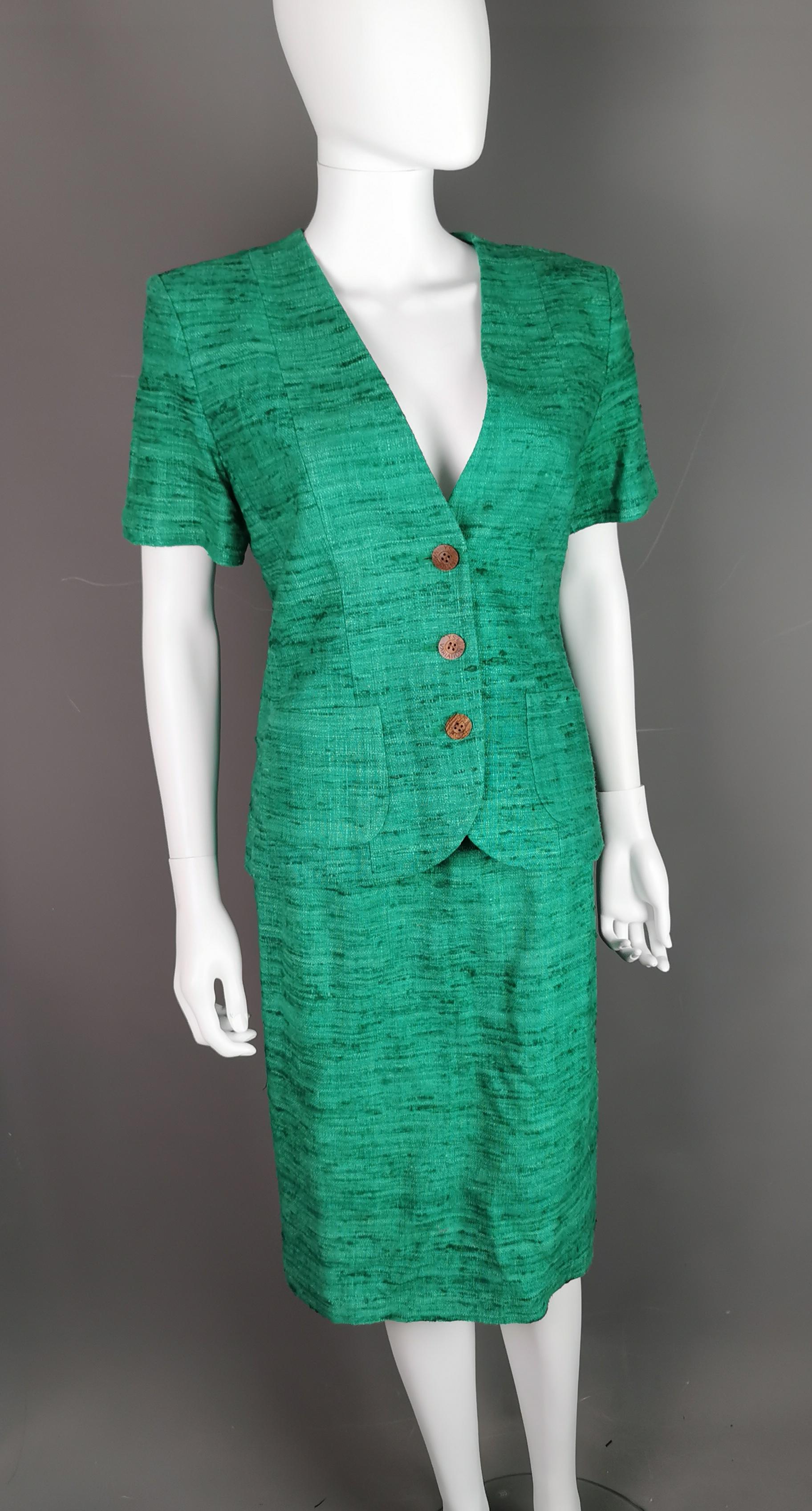 A gorgeous vintage YSL Variation green Slub silk skirt suit.

Hailing from the 1980s when power dressing was the go to this YSL skirt suit is made from the finest Slub Silk with a boucle like texture and a wool appearance, also lined in green