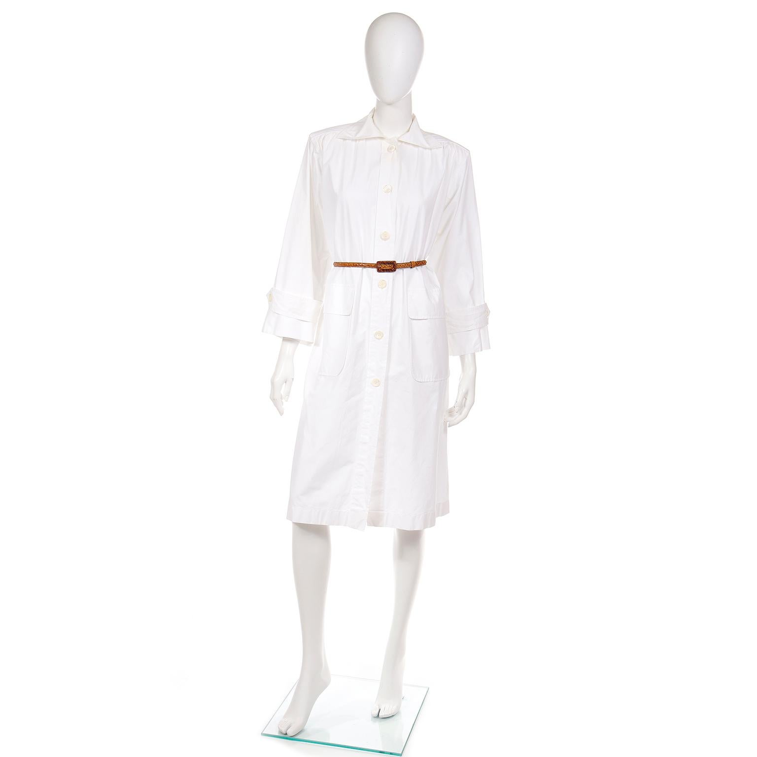 This vintage early 1980's Yves Saint Laurent white cotton duster style coat or coat dress is another YSL take on the utilitarian smock style dresses and tops he designed in the 1970's.
This easy to wear coat or coat dress has cream button closures
