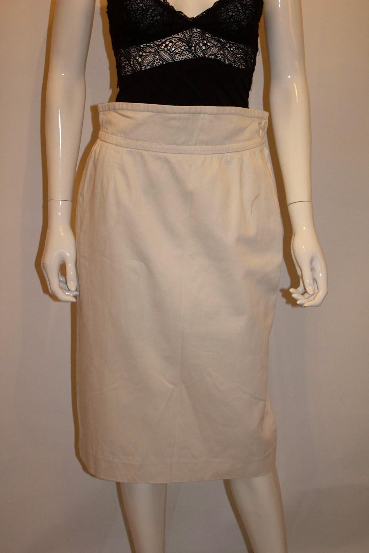 A wonderful white skirt for Fall, by Yves Saint Laurent, variation line. The skirt is in a thick white cotton, and has a wide waistband, zip opening on the left hand side and a pocket on each side. It has a 12''slit at the back . Measurements Waist