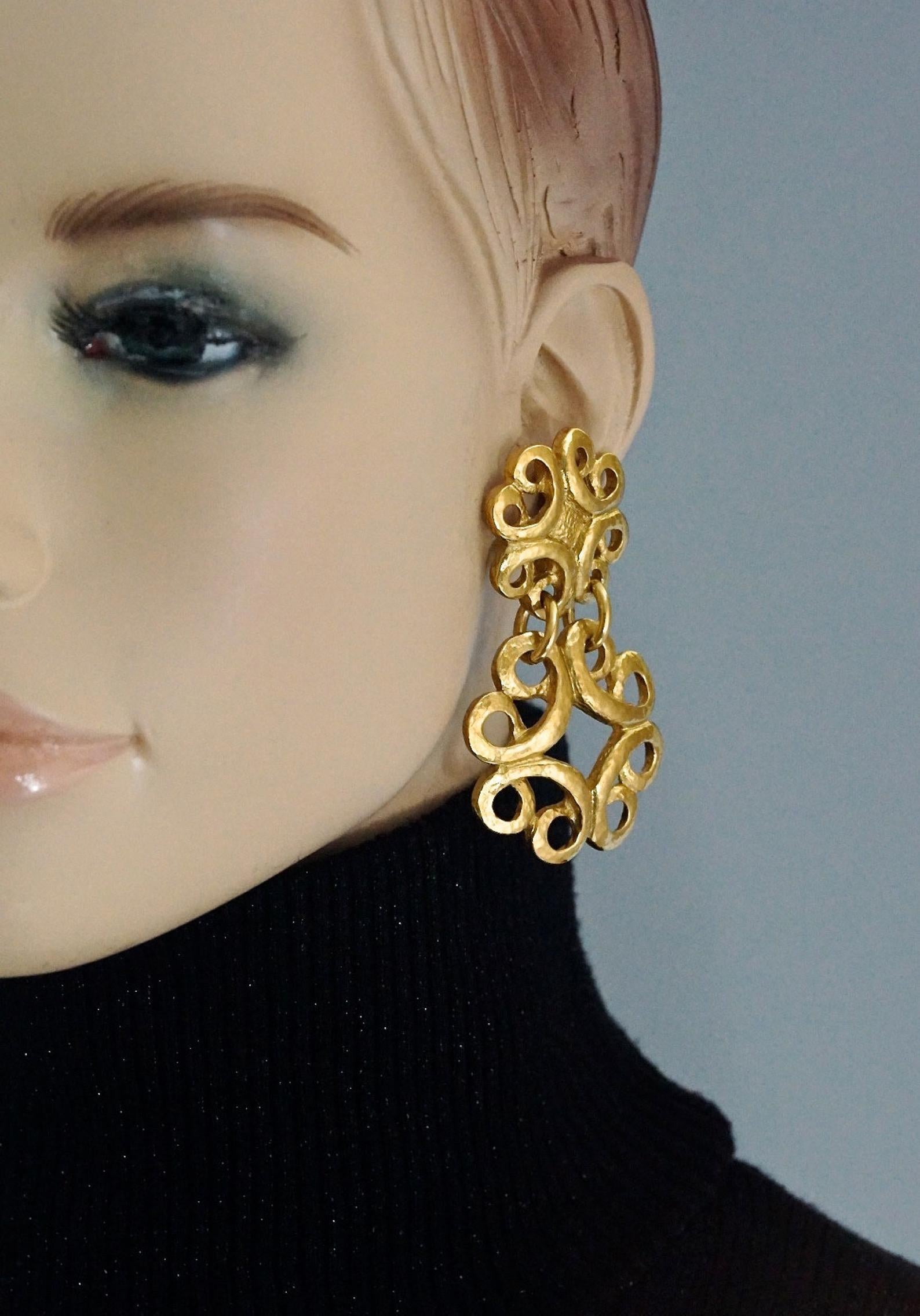 Vintage YVES SAINT LAURENT Ysl Arabesque Dangling Earrings

Measurements:
Height: 2 6/8 inches (7.4 cm)
Width: 1 6/8 inches (4.2 cm)
Weight per Earring: 30 grams

Features:
- 100% Authentic YVES SAINT LAURENT.
- Arabesque style gilt metal.
- Gold