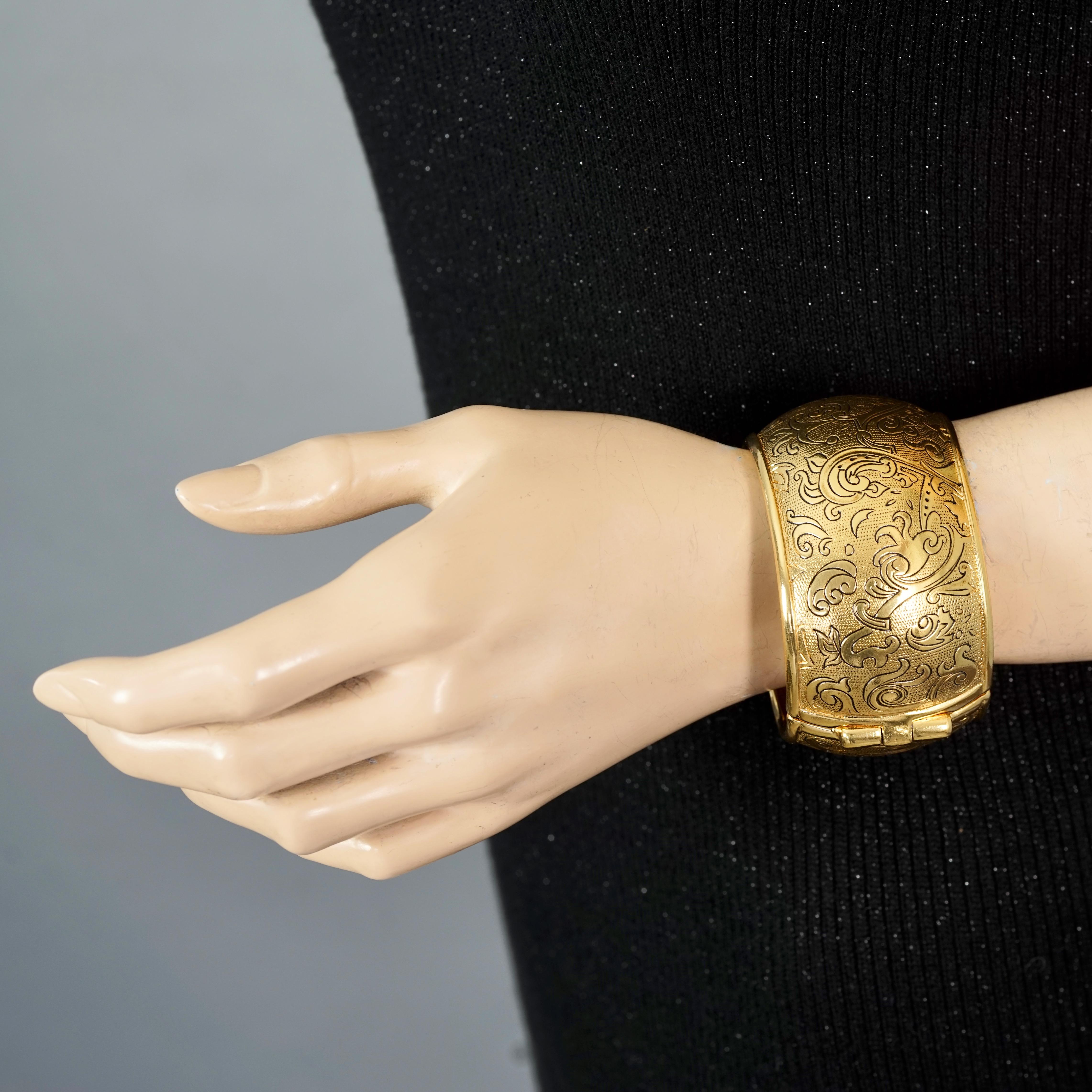 Vintage YVES SAINT LAURENT Ysl Arabesque Textured Cuff Bracelet

Measurements:
Height: 1.65 inches (4.2 cm)
Circumference: 6.88 inches (17.5 cm)

Features:
- 100% Authentic YVES SAINT LAURENT.
- Arabesque engraved pattern in black.
- Gold tone