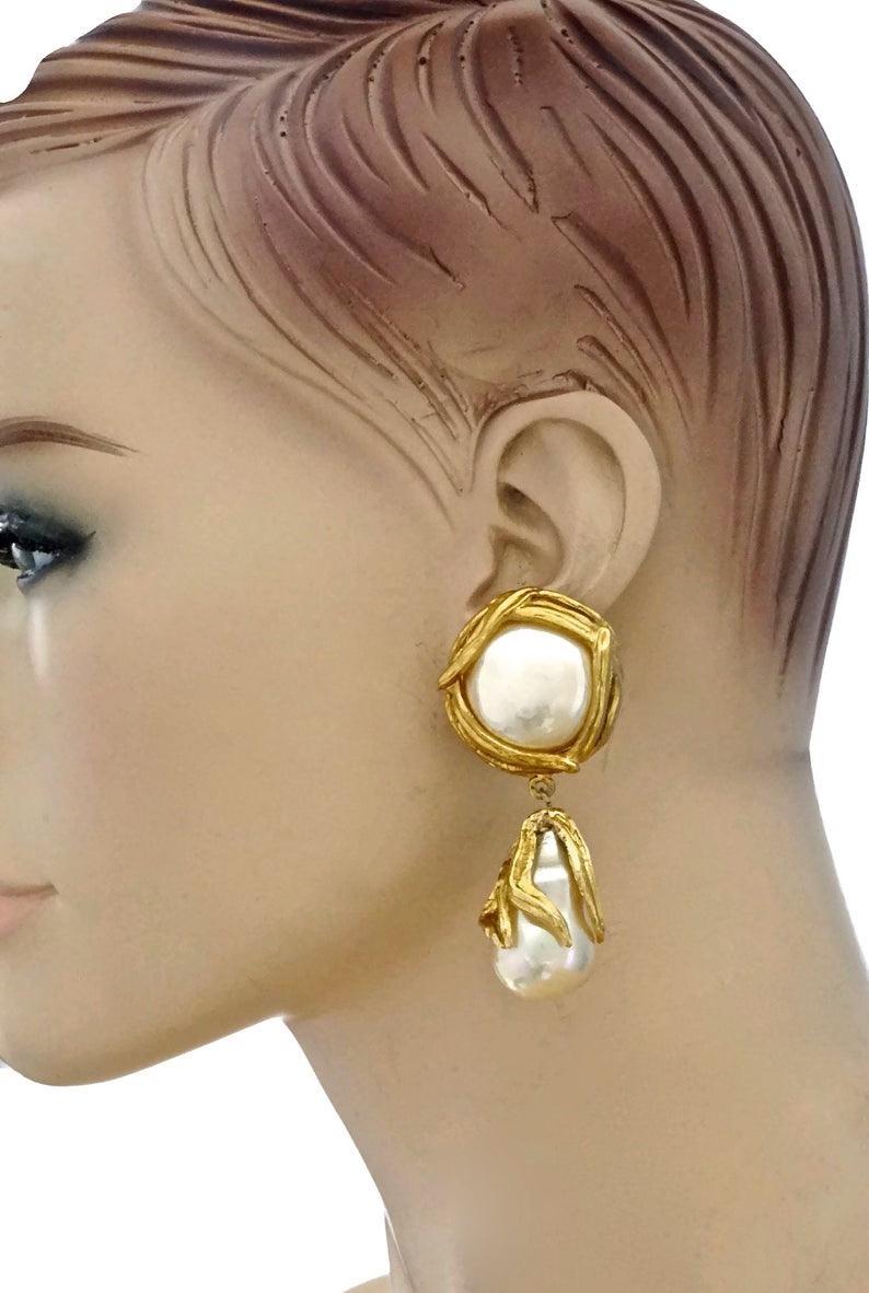 Vintage YVES SAINT LAURENT Ysl by Robert Goossens Pearl Drop Earrings

Measurements:
Height: 2.75 inches (7 cm)
Width: 1.22 inches (3.1 cm)
Weight: 39 grams

Features:
- 100% Authentic YVES SAINT LAURENT by Robert Goossens.
- Pearl drop/ dangling
