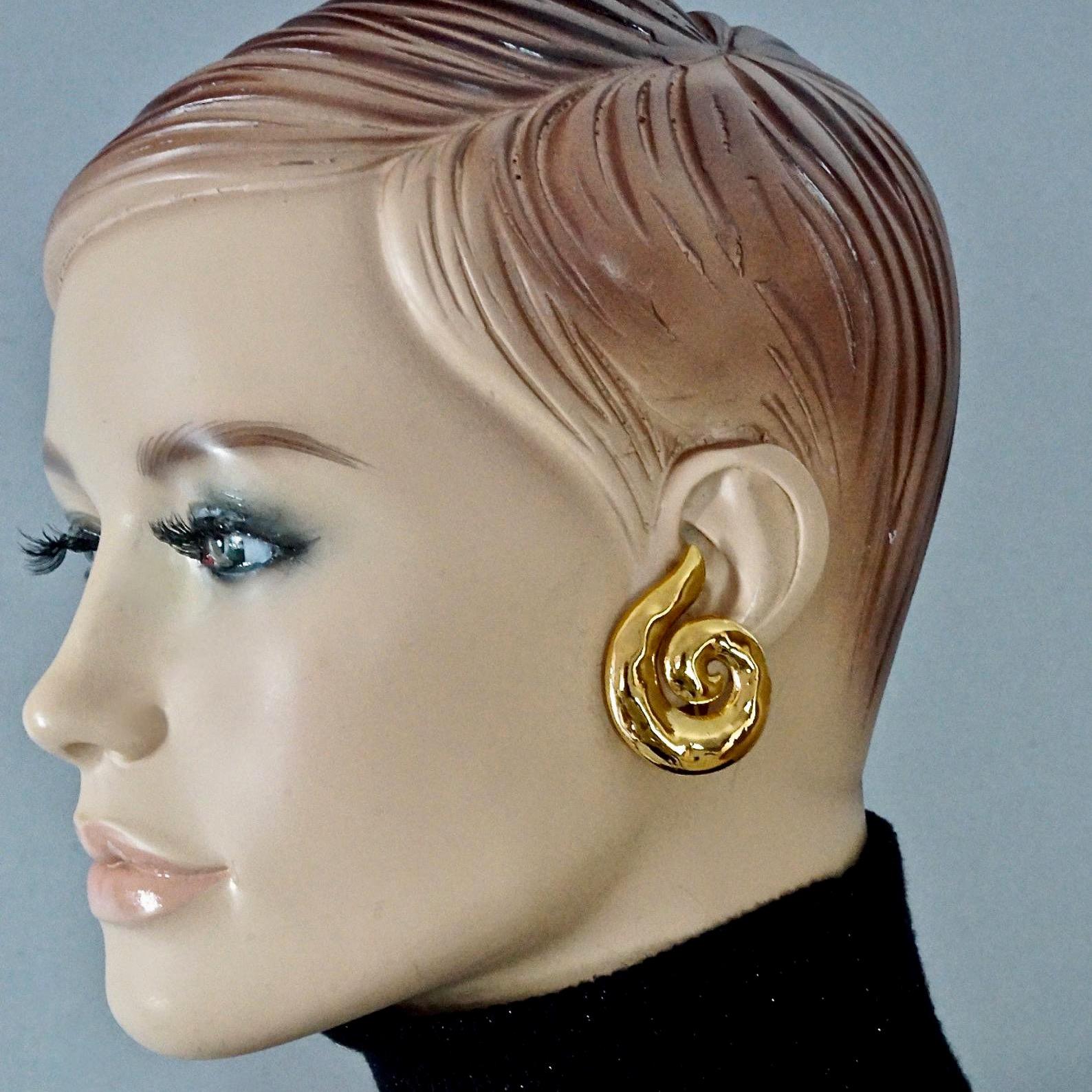 Vintage YVES SAINT LAURENT Ysl Coiled Spiral Earrings

Measurements:
Height: 1.65 inches (4.2 cms)
Width: 1.34 inches (3.4 cms)
Weight per Earring: 12 grams

Features:
- 100% Authentic YVES SAINT LAURENT.
- Coiled spiral hammered gilt earrings.
-