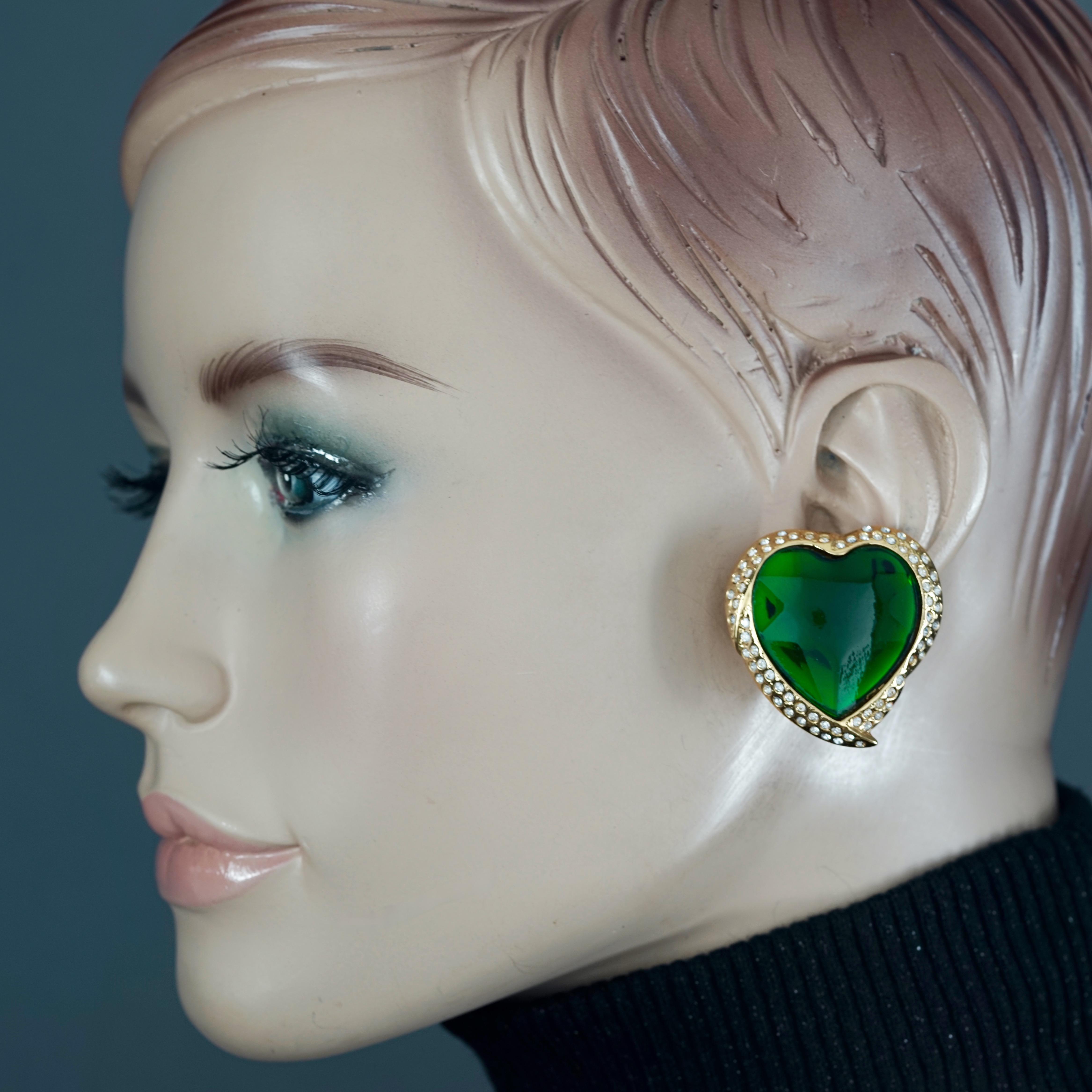 Vintage YVES SAINT LAURENT Ysl Emerald Green Faceted Heart Rhinestone Earrings

Measurements:
Height: 1.42 inches (3.6 cm)
Width: 1.38 inches (3.5 cm)
Weight per Earring: 16 grams

Features:
- 100% Authentic YVES SAINT LAURENT.
- Raised faceted