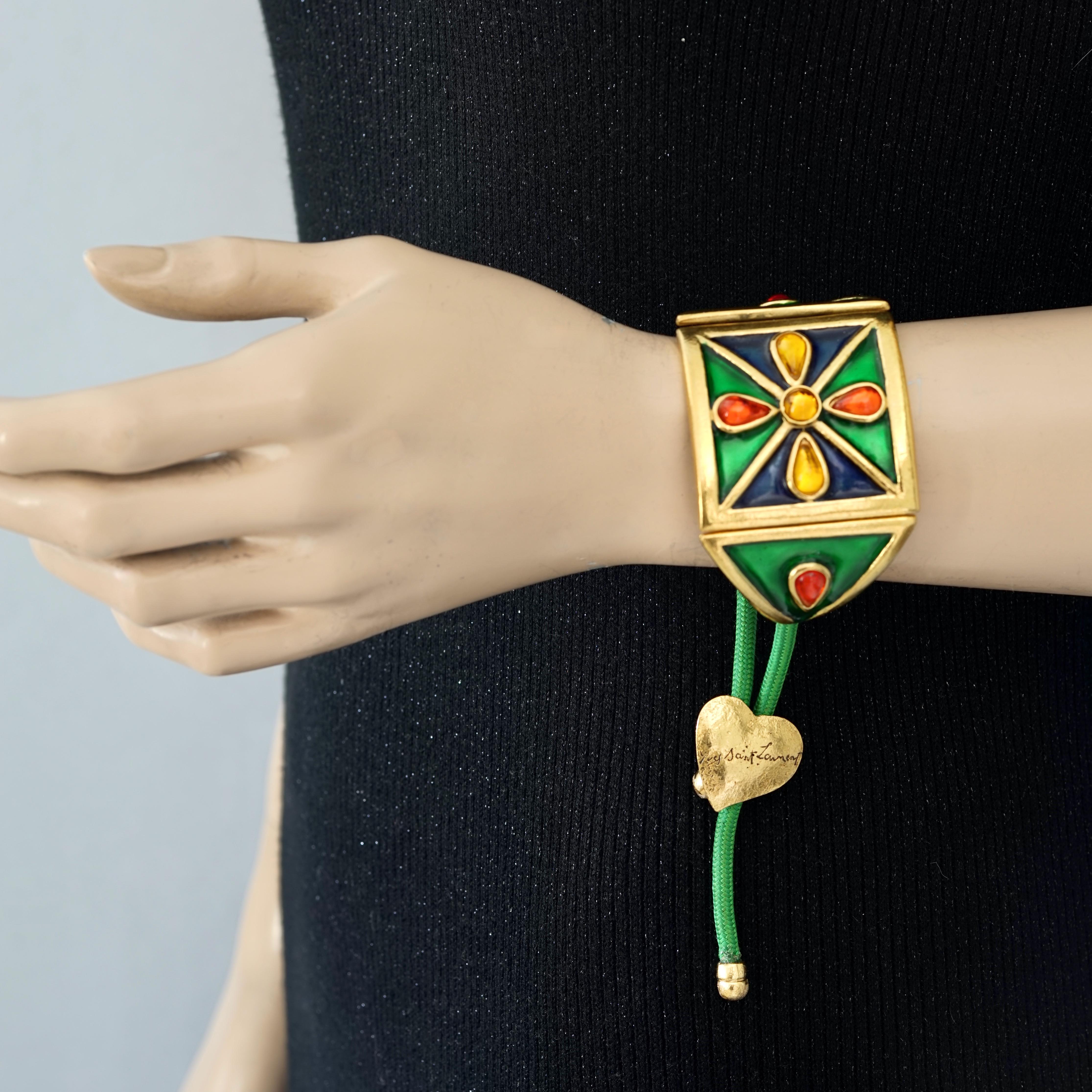 Vintage YVES SAINT LAURENT Ysl Flower Poured Glass Enamel Cord Cuff Bracelet

Measurements:
Height: 1.81 inches (4.6 cm)
Interior Width Metal Part: 4.33 inches (11 cm)
Length of Cord: 3.54 inches (9 cm) each sides

Features:
- 100% Authentic YVES