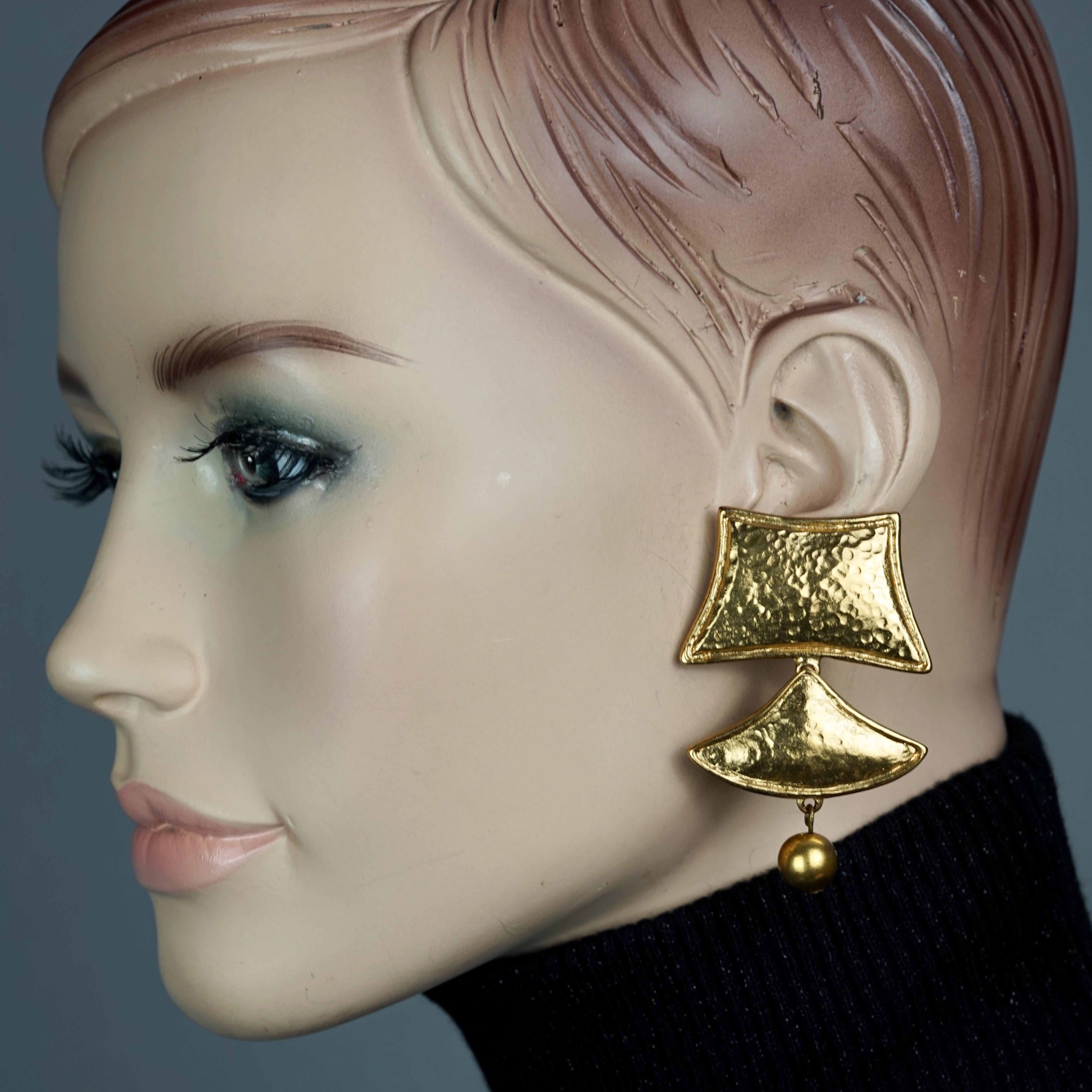 Vintage YVES SAINT LAURENT Ysl Geometric Tiered Earrings

Measurements:
Height: 2.44 inches (6.2 cm)
Width: 1.65 inches (4.2 cm)
Weight per Earring: 22 grams

Features:
- 100% Authentic YVES SAINT LAURENT.
- 3 Tiered hammered gilt geometric dangling