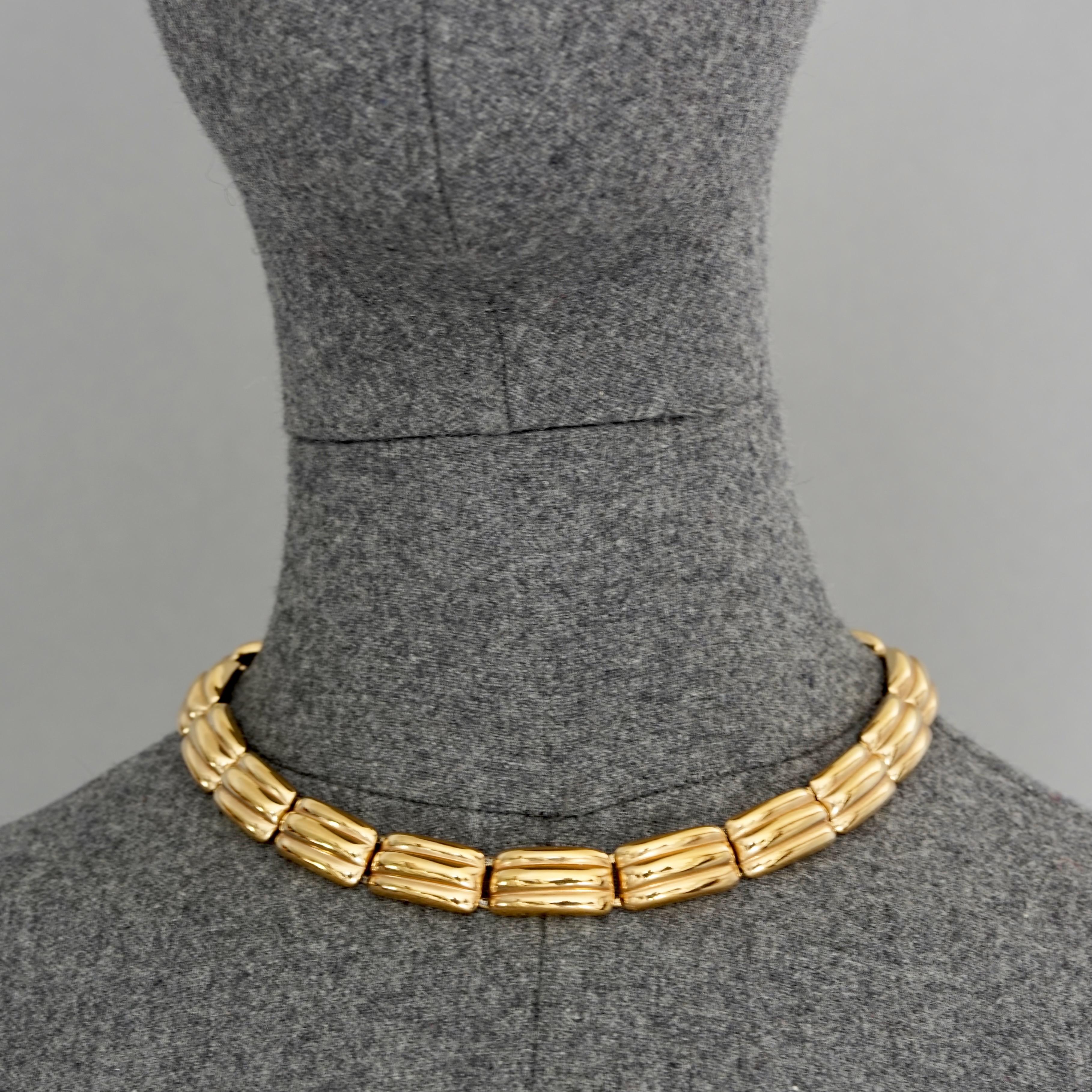 Vintage YVES SAINT LAURENT Ysl Gilt Link Choker Necklace

Measurements:
Height: 0.51 inch (1.3 cm)
Wearable Length: 15.35 inches (39 cm)

Features:
- 100% Authentic YVES SAINT LAURENT.
- Gilt link choker necklace.
- Gold tone hardware.
- Box clasp