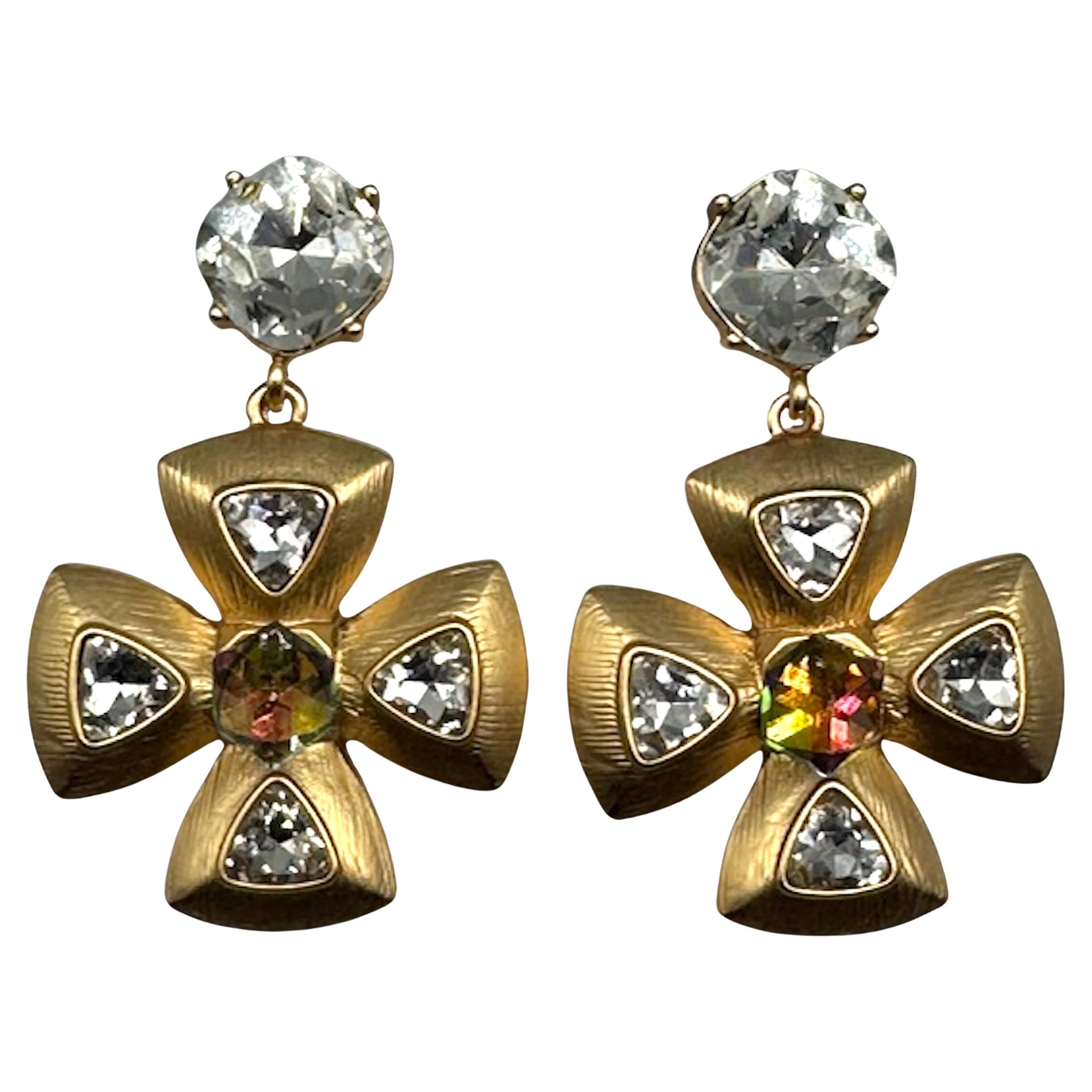 Diese atemberaubenden Vintage-Ohrringe von YSL (Yves Saint Laurent) zeichnen sich durch ihr einzigartiges Design in Form eines Malteserkreuzes aus, das elegant aus goldfarbenem Metall gefertigt ist. Die Ohrringe sind mit schimmernden Strasssteinen,