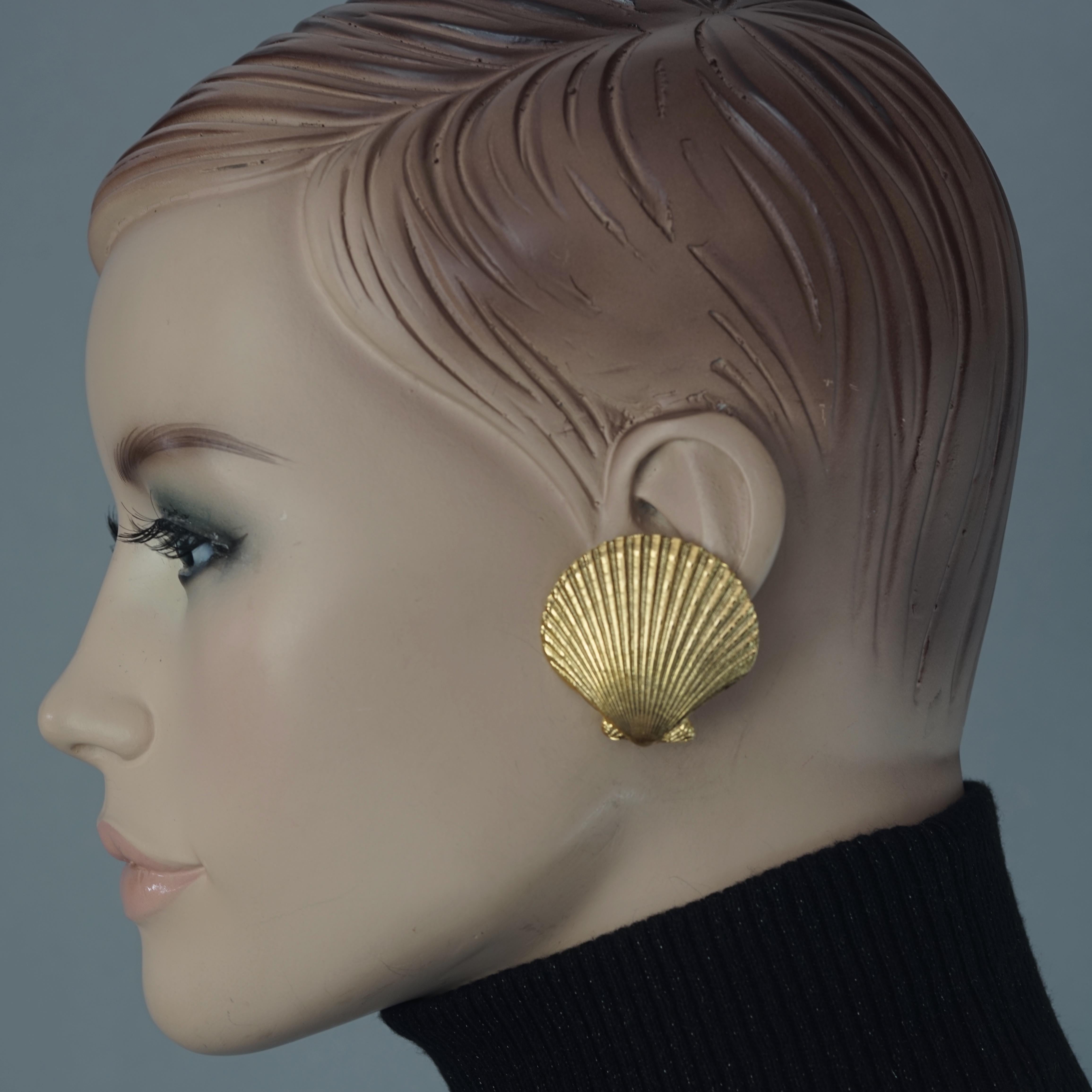 Vintage YVES SAINT LAURENT Ysl Golden Shell Earrings

Measurements:
Height: 1.57 inches (4 cm)
Width: 1.57 inches (4 cm)
Weight per Earring: 13 grams

Features:
- 100% Authentic YVES SAINT LAURENT.
- Textured clam shell shape earrings.
- Gold