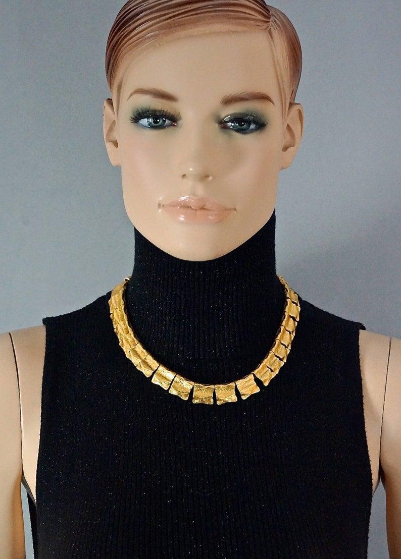 Vintage YVES SAINT LAURENT Ysl Hammered Gilt Flap Charm Necklace

Measurements:
Height: 0.59 inch (1.5 cm)
Wearable Length: 17.12 inches to 18.30 inches (43.5 cm to 46.5 cm)

Features:
- 100% authentic YVES SAINT LAURENT.
- Hammered gilt flap