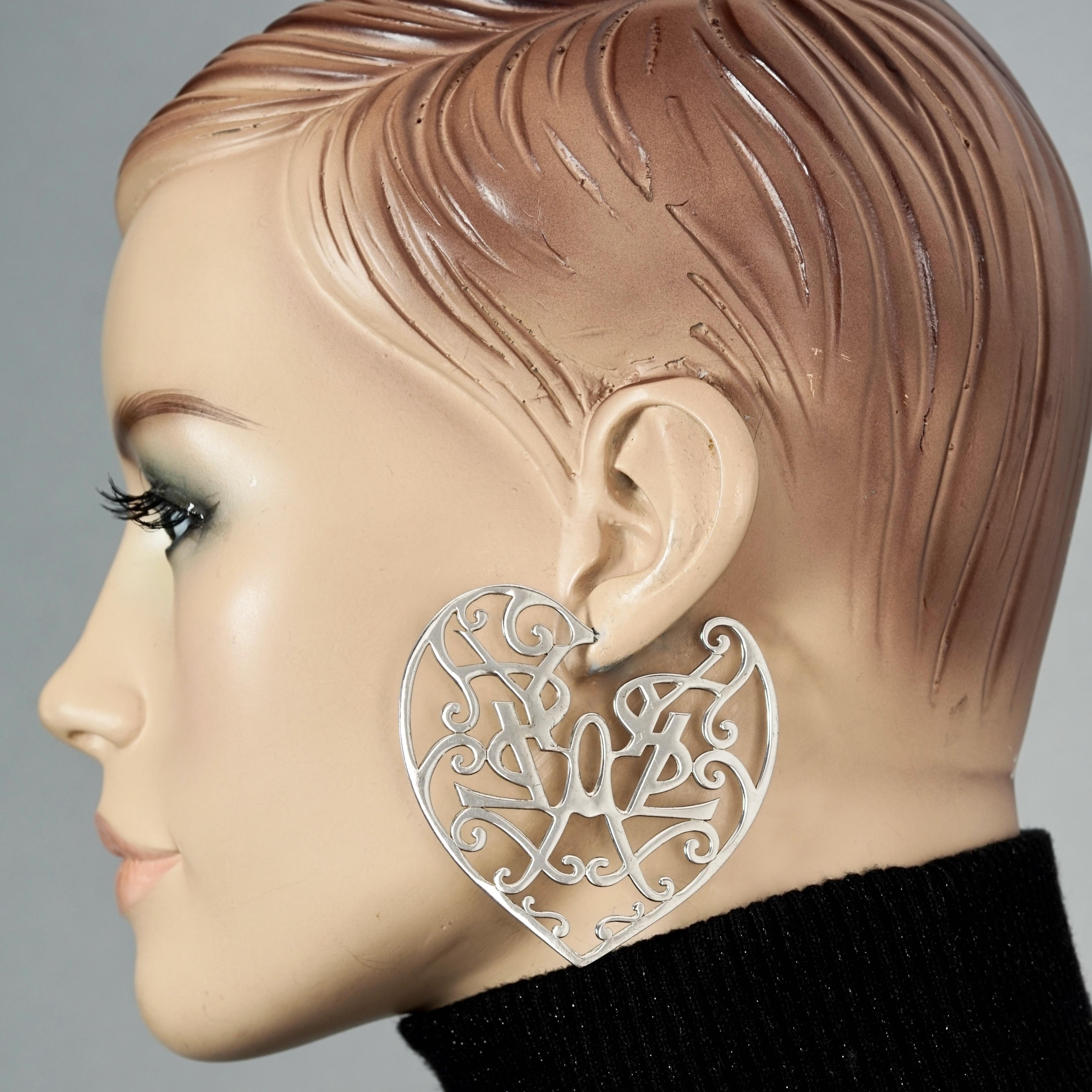 Vintage YVES SAINT LAURENT Ysl Heart Logo Abstract Openwork Hoop Silver Earrings

Measurements:
Height: 2.48 inches (6.3 cm)
Width: 2.63 inches (6.7 cm)
Weight per Earring: 13 grams

Features:
- 100% Authentic YVES SAINT LAURENT.
- Massive creole