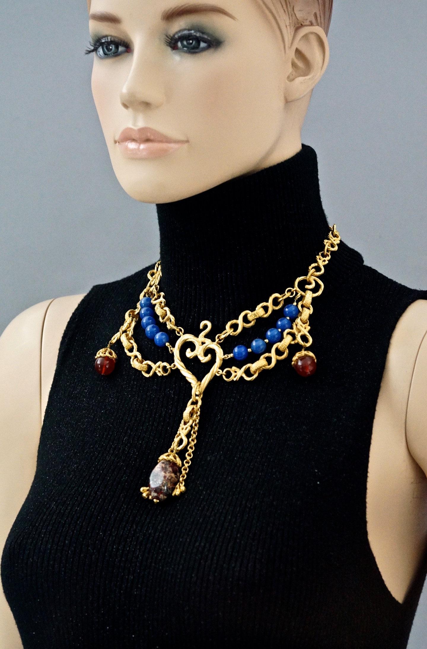 Vintage YVES SAINT LAURENT Ysl Heart Tiered Gilt Bead Necklace

Measurements:
Height: 4.92 inches (12.5 cm)
Wearable Length: 17.51 inches (44.5 cm) until 19.48 inches (49.5 cm)

Features:
- 100% Authentic YVES SAINT LAURENT.
- Textured heart