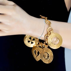 Braccialetto vintage Yves Saint Laurent con charm a medaglione con l'iconico emblema YSL