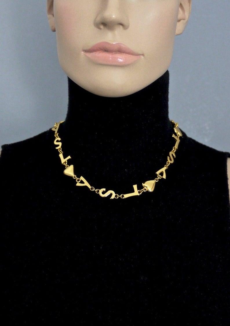 Vintage YVES SAINT LAURENT Ysl Initial Logo Heart Star Necklace

Measurements:
Height: 0.51 inch (1.3 cm)
Wearable Length: 17.32 inches to 19.29 inches (44 cm) to (49 cm)

Features:
- 100% Authentic YVES SAINT LAURENT.
- YSL logos/ initials with