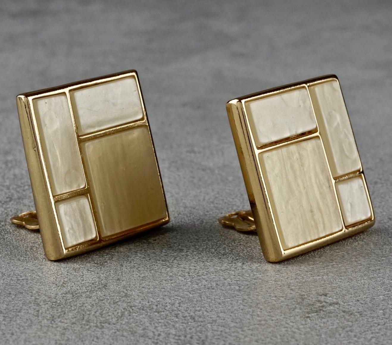 Vintage YVES SAINT LAURENT Ysl Mother of Pearl Mondrian Earrings

Measurements:
Height: 1.26 inches (3.2 cm)
Width: 1.26 inches (3.2 cm)
Weight per Earring: 20 grams

Features:
- 100% Authentic YVES SAINT LAURENT.
- Square earrings in Piet Mondrian