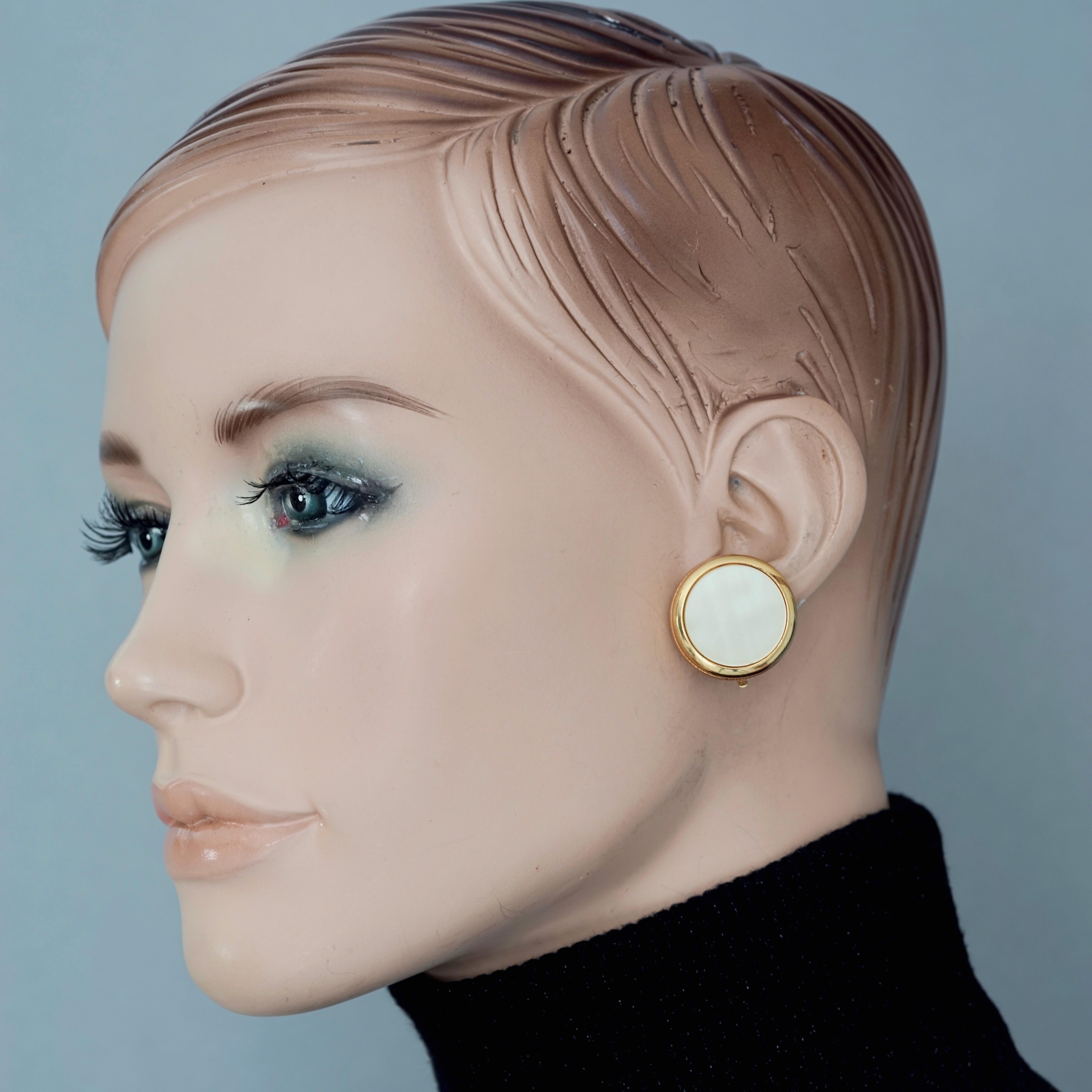 Vintage YVES SAINT LAURENT Ysl Nacre Disc Earrings

Measurements:
Height: 1 inch (2.5 cm)
Width: 1 inch (2.5 cm)
Weight: 16 grams

Features:
- 100% Authentic YVES SAINT LAURENT.
- Round mother of pearl/ nacre earrings.
- Gold tone hardware.
- Signed