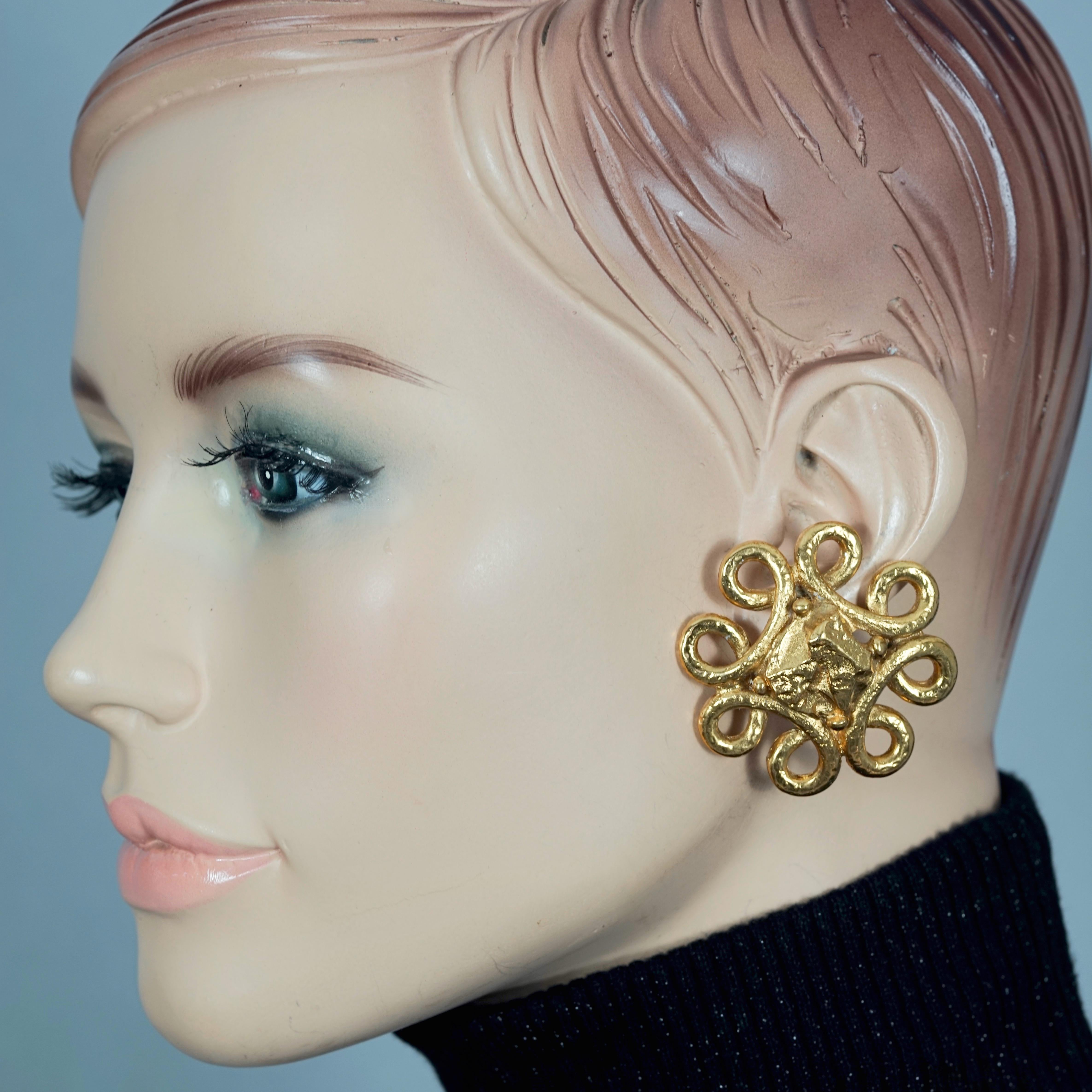Vintage YVES SAINT LAURENT Ysl Nugget Loop Earrings

Measurements:
Height: 1.73 inches (4.4 cm)
Width: 1.73 inches (4.4 cm)
Weight per Earring: 21 grams

Features:
- 100% Authentic YVES SAINT LAURENT.
- Chunky loop pattern earrings with textured