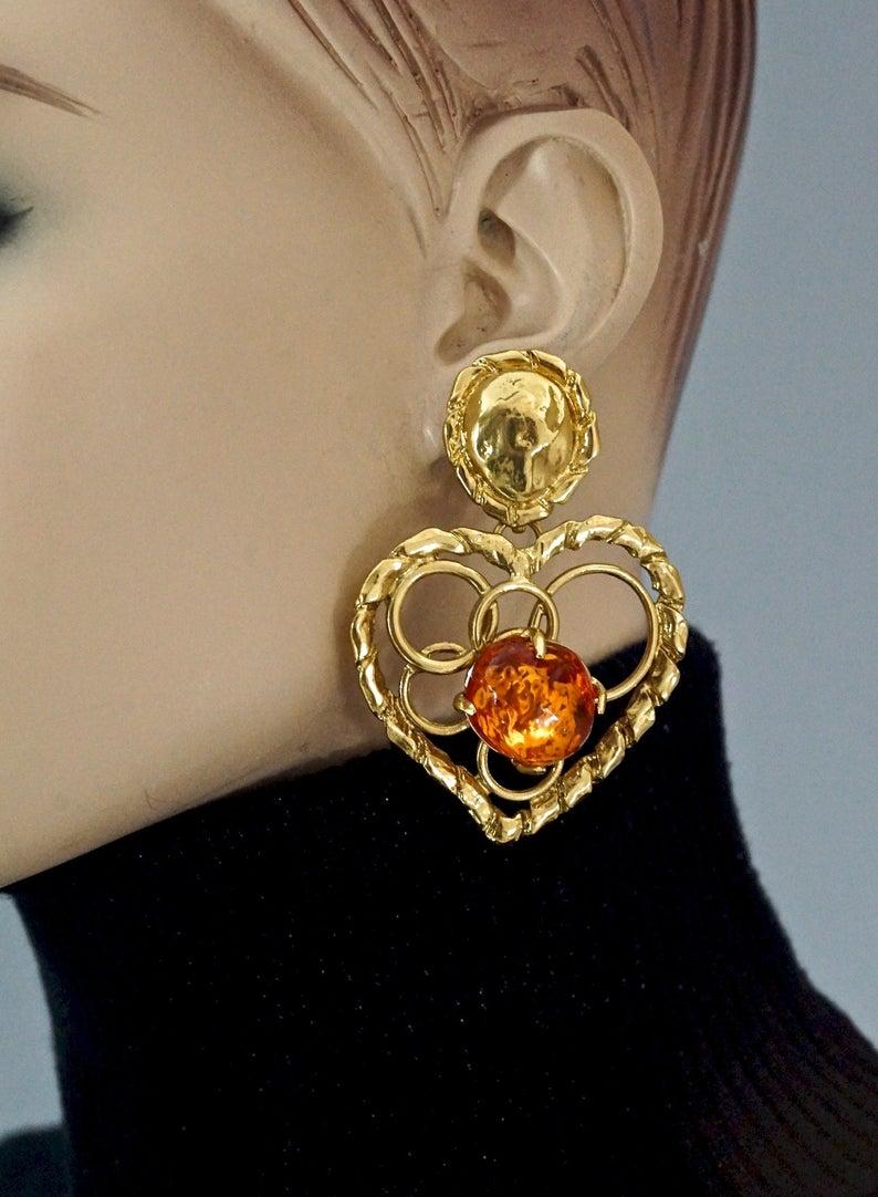 Vintage YVES SAINT LAURENT Ysl by Robert Goossens Openwork Heart Amber Resin Dangling Earrings

Measurements:
Height: 2.79 inches (7.1 cm)
Width: 2 inches (5.1 cm)
Weight per Earring: 32 grams

Features:
- 100% Authentic YVES SAINT LAURENT by Robert