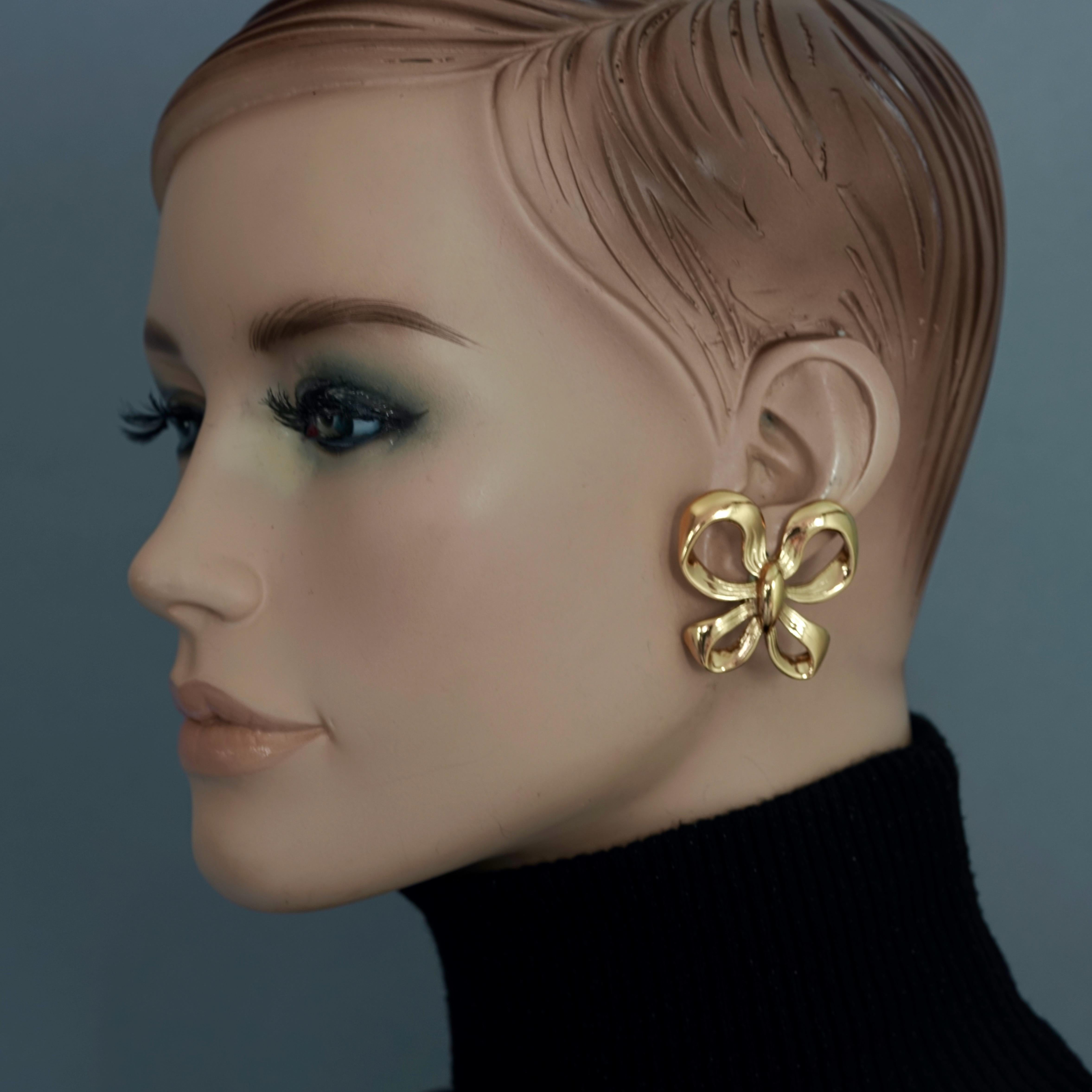 Vintage YVES SAINT LAURENT Ysl Ribbon Bow Earrings

Measurements:
Height: 1.61 inches (4.1 cm)
Overall Length: 1.49 inches (3.8 cm)
Weight per Earring: 13 grams

Features:
- 100% Authentic YVES SAINT LAURENT .
- Ribbon/ bow earrings.
- Gold tone.
-